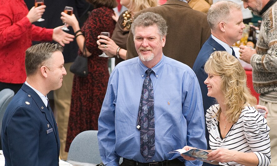Debra Caulk (right), honorary commander for the 712th Aircraft Maintenance Squadron, her husband Rodney, and Maj. John Foran, 512 AMXS, mingle during social hour at the Dover Air Force Base, Del., 2011 Honorary Commanders Induction Ceremony Jan. 7, 2011.  The induction ceremony is held annually to induct local community leaders as honorary commanders of an organization on base. (U.S. Air Force photo/Jason Minto)