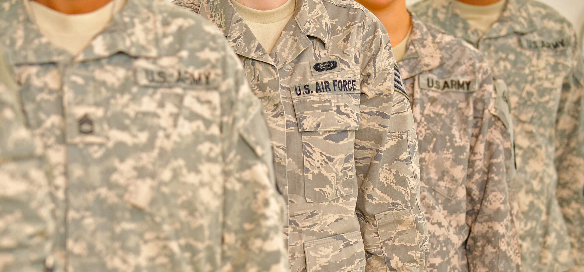 Service members stand in formation for a photo Jan. 13, on Camp Victory, Iraq. Staff Sgt. Ashley Le Duc works in a joint military unit combined with Air Force, Army, Navy and Marines. (U.S. Air Force photo by Senior Airman Andrew Lee/Released)