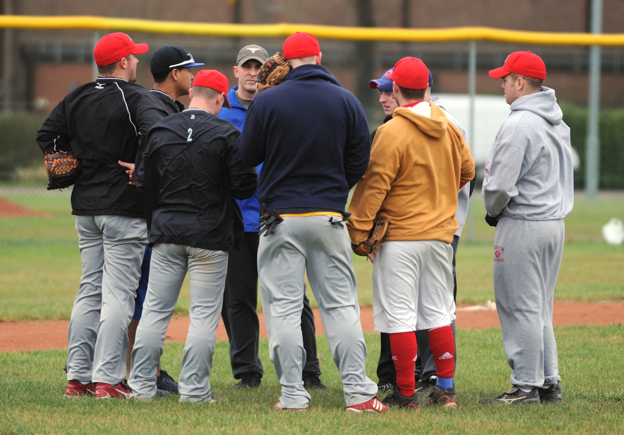 RAF MILDENHALL, England -- Members of RAFs Mildenhall, Lakenheath and Feltwell huddle up before baseball tryouts Jan. 15, 2011, at the RAF Feltwell baseball fields.  The tryouts were for the Mildenhall Bulldogs, a team comprised of members from these three RAF bases. (U.S. Air Force photo/Senior Airman Tabitha M. Lee) 