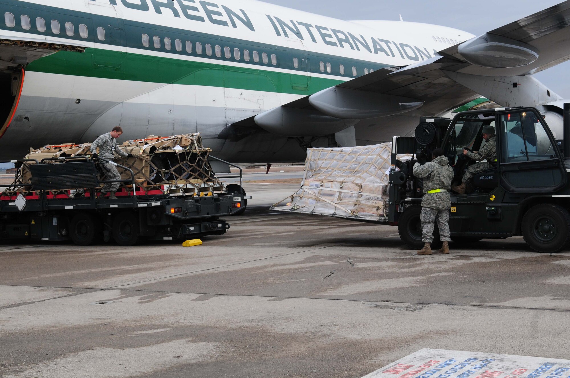 Senior Airmen Emmanuel Koomson, Jason Ray, and Jonathan Welker-Cantrell from the 728th Air Mobility Squadron, offload cargo from an Evergreen Boeing 747 using the cargo hub feeder process.  The cargo will be transferred to a C-17 for movement downrange to the U.S. Central Command area of responsibility. In 2010, the 728 AMS transported 103,380 tons of cargo on 5,880 missions in support of Operations ENDURING FREEDOM, IRAQI FREEDOM and NEW DAWN. (U.S. Air Force photo by Senior Airman Ashley Wood/Released) 