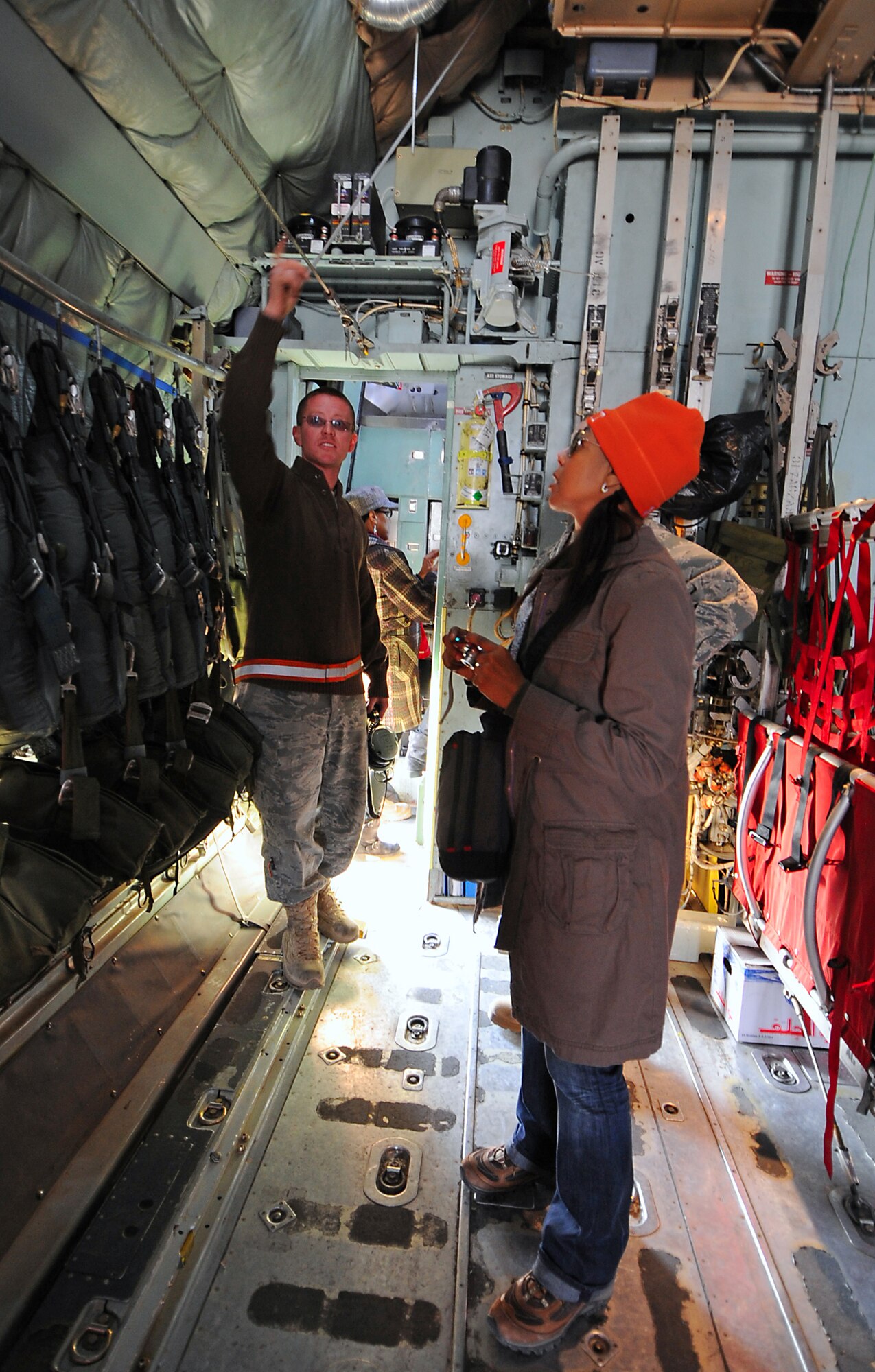 Senior Airman Sammie Wright explains the importance of the static line retriever and its role in paratroop drops to Terry Ellis of En Vogue Jan. 16. This is En Vogue's first stop on their first tour in the area of responsibility. Airman Wright is a member of the 386th Expeditionary Aircraft Maintenance Squadron. (U.S. Air Force photo by Senior Airman Cynthia Spalding)