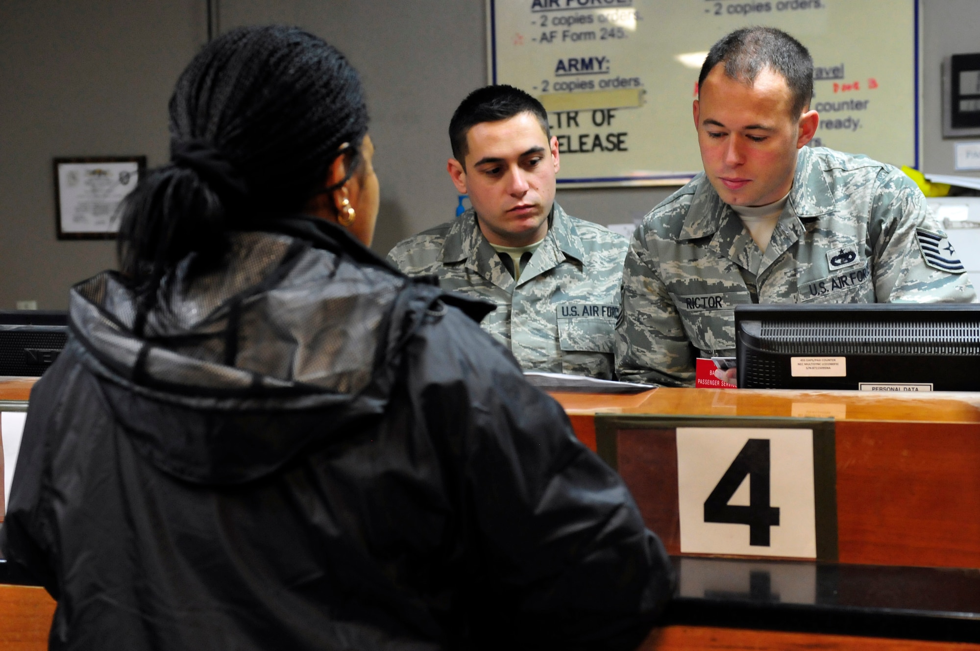 455th Expeditionary Aerial Port Squadron Passenger Service Supervisor, Tech. Sgt. Jason Rictor assists a passenger while training Senior Airman Phil Garcia during his first day at Bagram Airfield, Jan. 18, 2011. Sergeant Rictor has been here for only a week and has already learned how the Air Force's busiest passenger terminal handles nearly 1800 daily passengers. Sergeant Rictor is a Gresham, Ore., native deployed from Travis Air Force Base, Calif., and Airman Garcia is a Grand Terrace, Calif., native deployed from March Air Force Base, Calif. (U.S. Air Force photo by Tech. Sgt. Michael Voss)