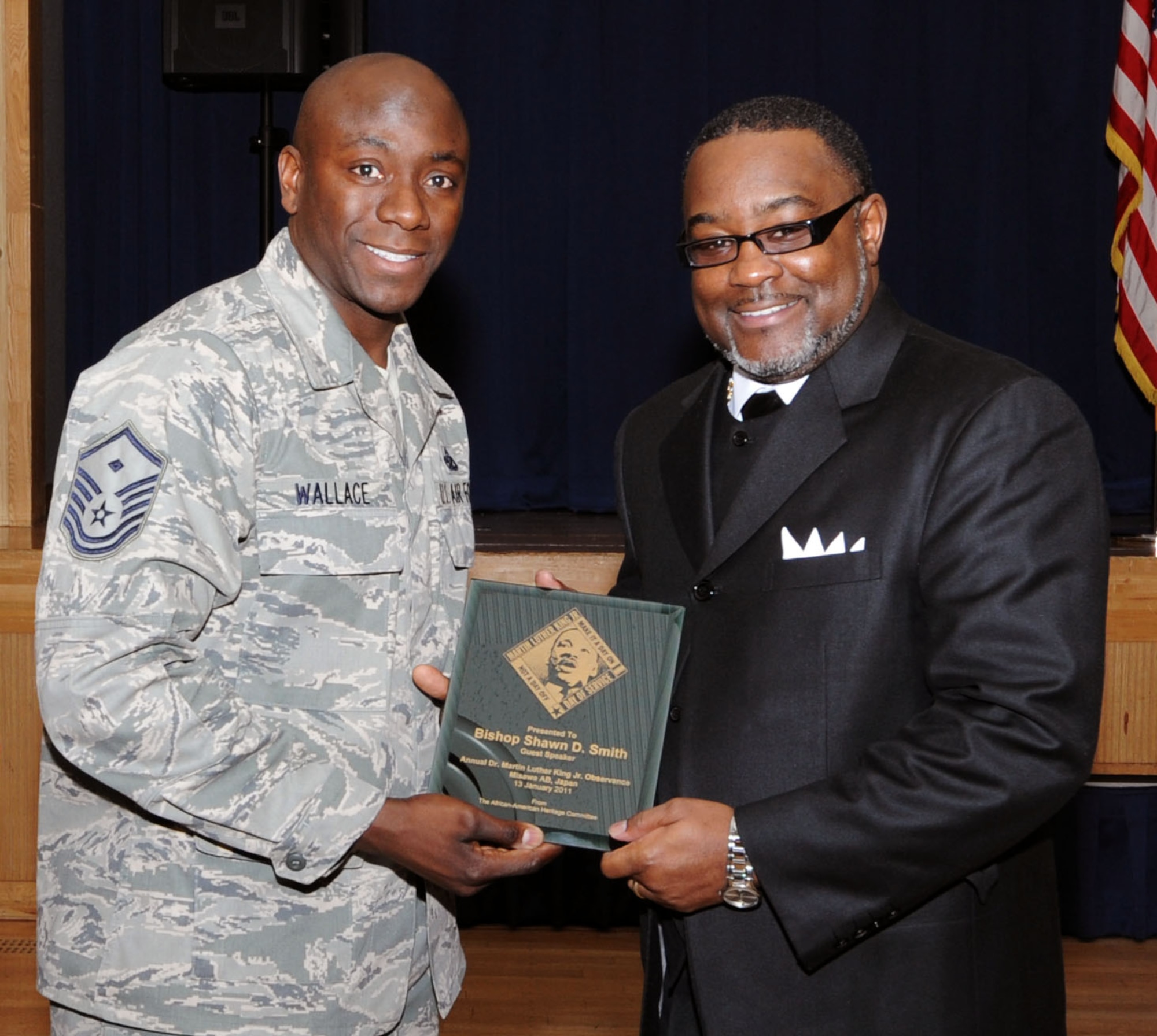 Bishop Shawn D. Smith of The First St. James Missionary Baptist Church, El Dorado, Arkansas receives a gift from Master Sgt. Shaffinie Wallace, 35th Aircraft Maintenance Squadron, during the Martin Luther King, Jr. luncheon at Misawa Air Base, Japan, Jan. 13, 2011. Bishop Smith retired from the United States Air Force as a master sergeant, who continues to serve visionary leadership for the Misawa?s community. (U.S. Air Force photo by Tech. Sgt. Russell McBride/Released)