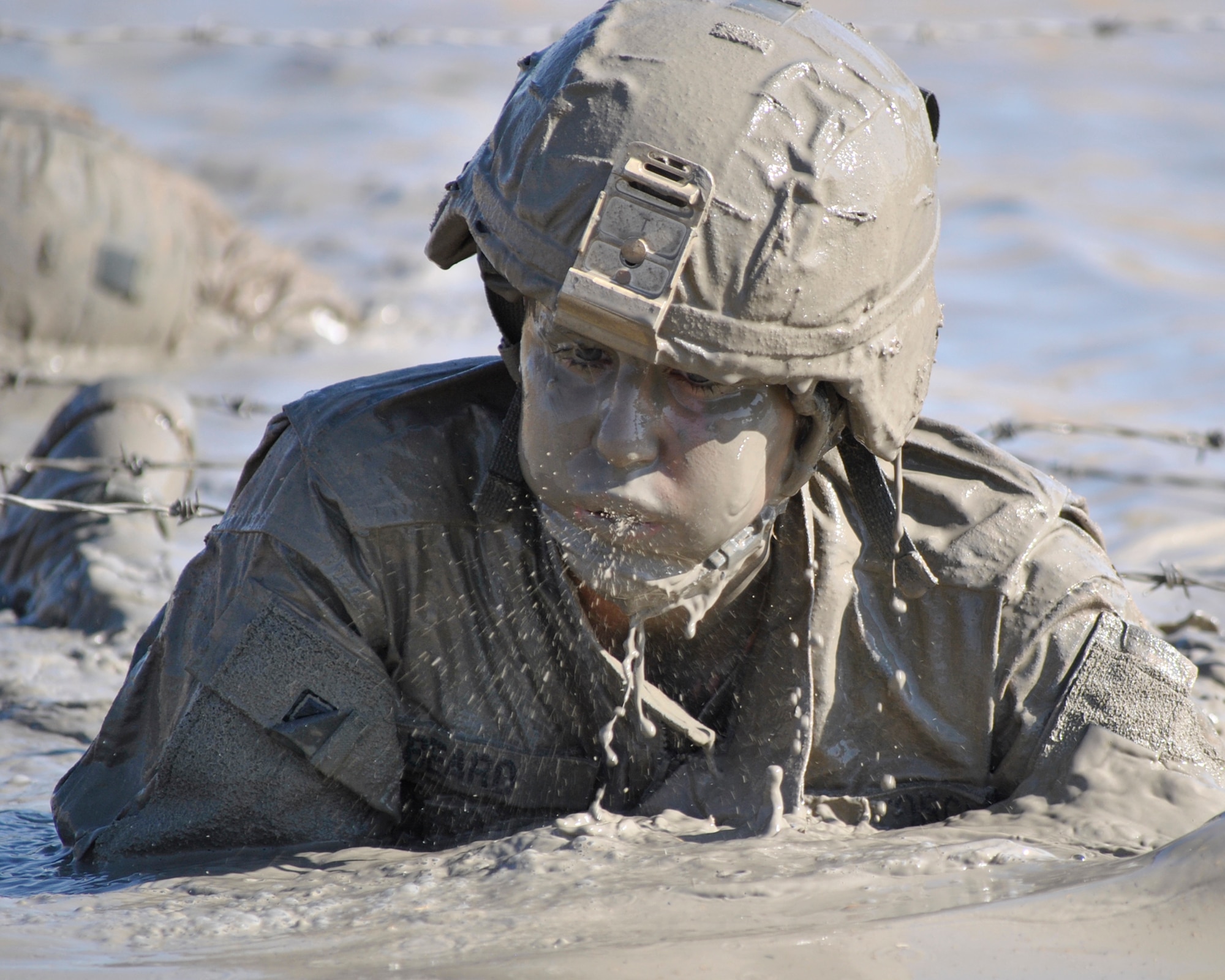 Senior Airman Courtney Beard, 467th Expeditionary Intelligence Squadron intelligence analyst, low-crawls through a mud pit Nov. 21 on Victory Base Complex, Iraq. The Brooklyn, N.Y., native was the first female Airman to complete the 18-hour Spur Ride, a series of mental and physical tests, held by the III Corps, Task Force Phantom. (U.S. Army photo by Sgt. Kelly K. Morehouse)