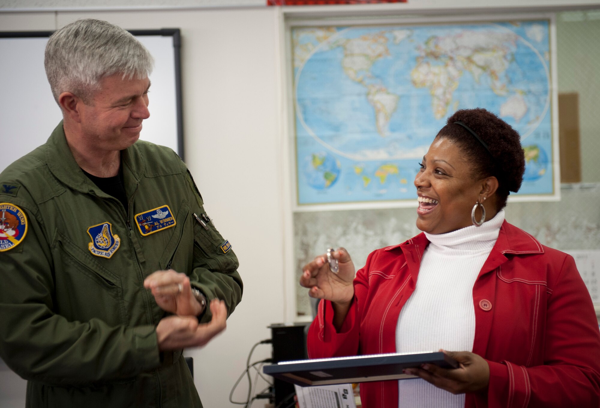 U.S. Air Force Col. Van Wimmer, 35th Fighter Wing vice commander, presents the "You Made a Difference" award and a 35th FW coin to Tammy Smith, Cummings Elementary School 2nd grade teacher, during a teacher meeting at Cummings Elementary School, Misawa Air Base, Japan; Jan. 11, 2011. The award recognizes the most outstanding teacher of the year from each of Misawa's Department of Defense District Schools. (U.S. Air Force photo by Staff Sgt. Samuel Morse/Released)