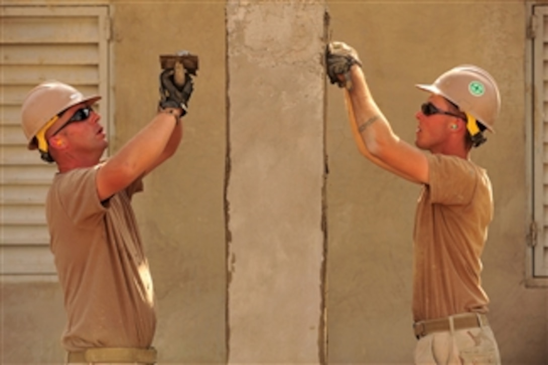 U.S. Navy Petty Officer Robert DeLuca (left) and Petty Officer Naethan Clark, both assigned to Naval Mobile Construction Battalion 74, Detail Horn of Africa, apply stucco to a schoolhouse construction project in Djibouti on Jan. 12, 2011.  The unit deployed to Combined Joint Task Force-Horn of Africa to assist in building host-nation partnerships and promoting regional stability throughout the region.  