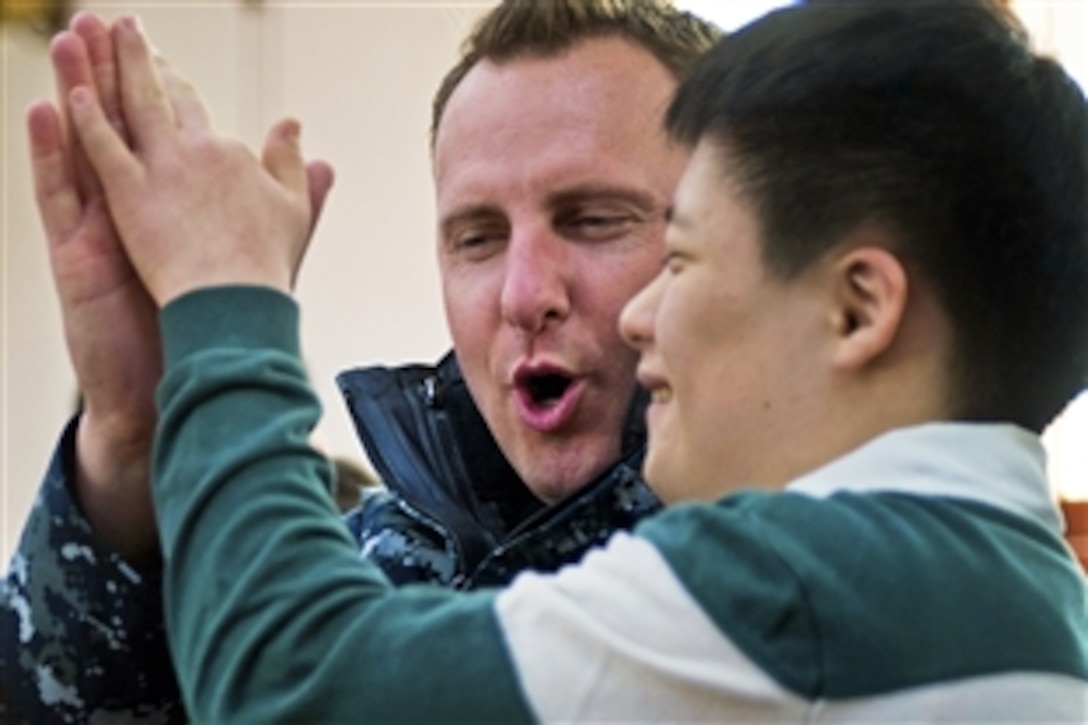 U.S. Navy Petty Officer 1st Class Joshua Stark celebrates with his teammate after winning a game at the Jinhae Jae-Hwal-Won home for handicapped children in Chinhae, South Korea, Jan. 12, 2011. Twenty-two sailors joined members of South Korea's military in a visit to the home during a port visit. Stark is assigned to the USS Stockdale, which is under way with the Carl Vinson Carrier Strike Group in the U.S. 7th Fleet area of responsibility.