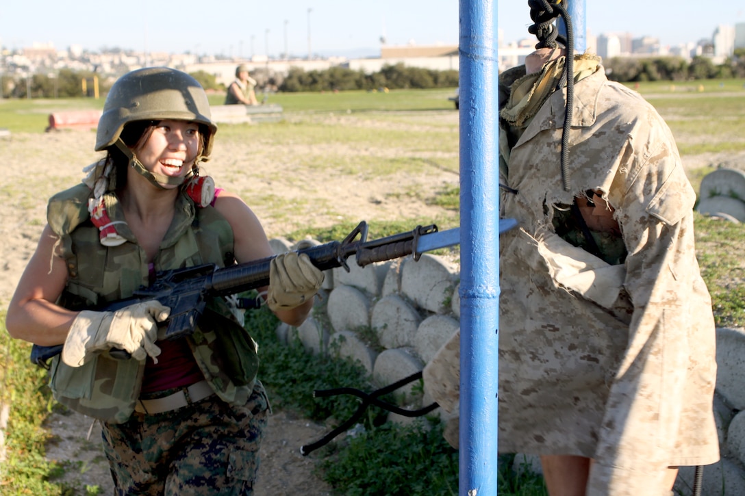 Jaymie Helle, counselor at St. Francis High School, St. Francis, Minn., enthusiastically attacks a dummy with her rubber bayonet. The educators are offered the chance to go through the Bayonet Assault Course to get an idea of what the recruits do on a day-to-day basis.