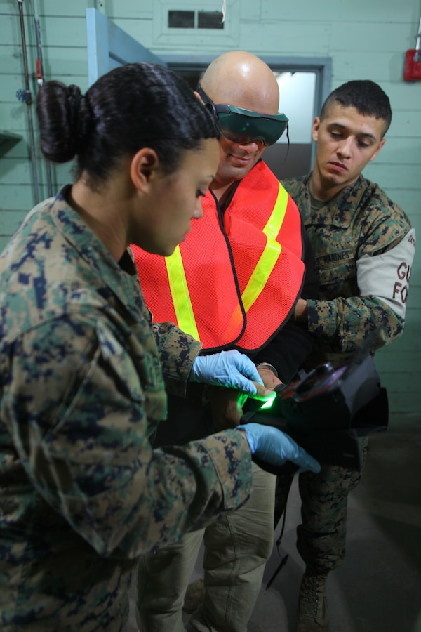 Marines with Military Police Detachment, Combat Logistics Battalion 24, 24th Marine Expeditionary Unit, process a simulated detainee here with the Secure Electronic Enrollment Kit (SEEK) Jan. 27, 2012. The detainee was captured during a mock raid conducted by 24th MEU’s Force Reconnaissance Platoon and the Security Element Platoon, Battalion Landing Team 1st Battalion, 2nd Marine Regiment, 24th MEU, at a Virginia Beach police training facility in Creeds. The raid was part of the 24th MEU’s Realistic Urban Training (RUT) exercise scheduled Jan. 5-20, which focuses on conducting off-base missions near the towns of Farmville and Creeds to prepare for the various operations they may conduct while deployed.