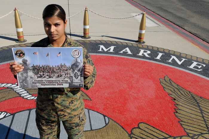 Lance Cpl. Sorina Langer, base operations flight clearance clerk, holds up a photo at the flight line on the Marine Corps Air Station in Yuma, Ariz., Jan. 18, 2011. The photo is of a Female Engagement Team she was a member of. Langer returned to the states Oct. 14, 2010, and came back to the air station Dec. 4, 2010, after an eight-month deployment to Marjah, Helmand Province, Afghanistan, in support of operations there. While overseas, she helped establish rapport with locals and villagers. Because males are allowed virtually no contact with Afghan females, female Marines are often cast in the role of mediator between the two.