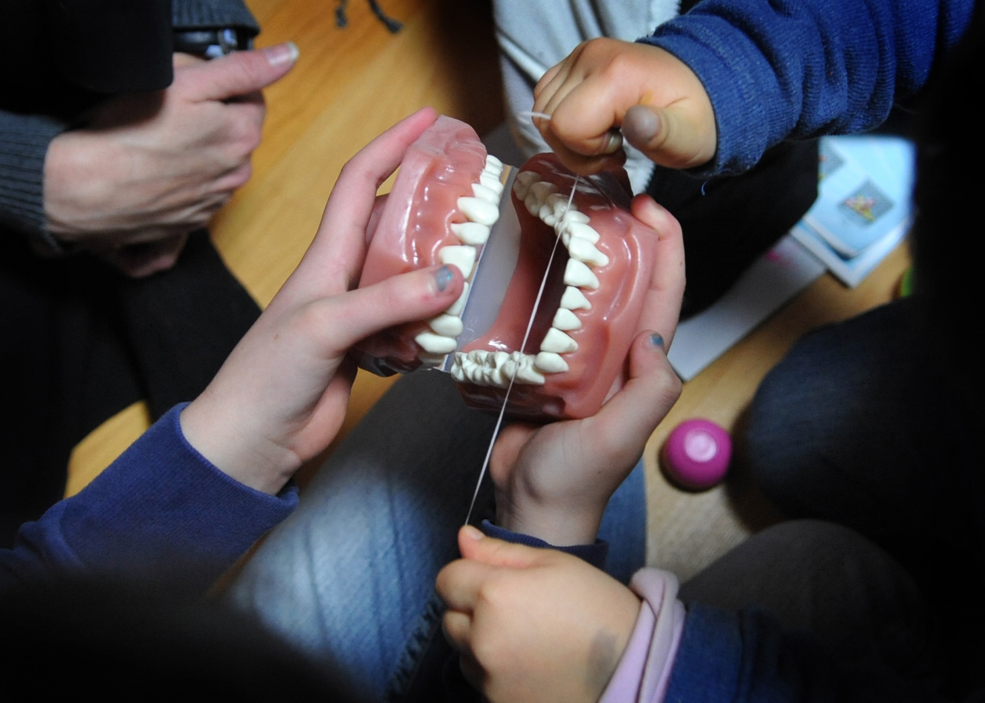 Children at the Cheonan orphanage learn how to properly floss their teeth during an orphanage trip by Osan Airmen Jan. 15.  The Osan base chapel organizes a monthly trip to local orphanges. Volunteers have the opportunity to play with and talk to the children. (U.S. Air Force photo by Senior Airman Evelyn Chavez)