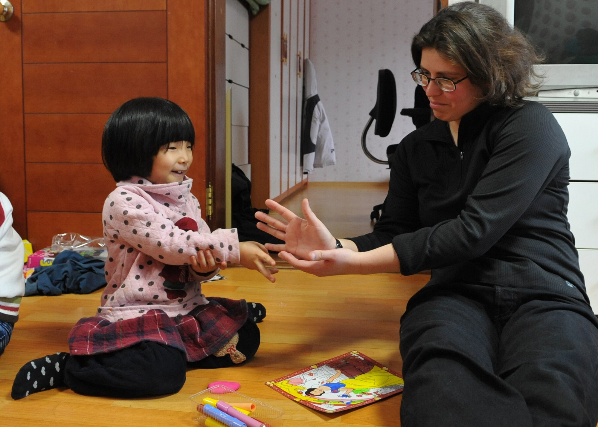 1st Lt. Katherine Kordecki, 51st Logistics Readiness Squadron, plays paper, rock, scissors with a child at the Cheonan orphanage during an orphanage trip by Osan Airmen Jan. 15.  The Osan base chapel organizes a monthly trip to local orphanges, where volunteers have the opportunity to play with and talk to the children. (U.S. Air Force photo by Senior Airman Evelyn Chavez)