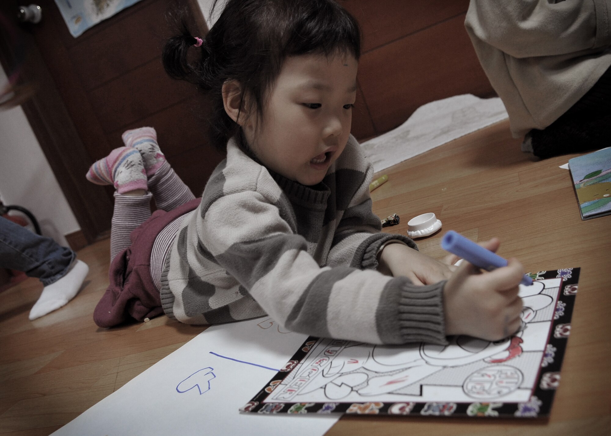 A child at the Cheonan orphanage colors during an orphanage trip by Osan Airmen Jan. 15.  The Osan base chapel organizes a monthly trip to local orphanges. Volunteers have the opportunity to play with and talk to the children. (U.S. Air Force photo by Senior Airman Evelyn Chavez)