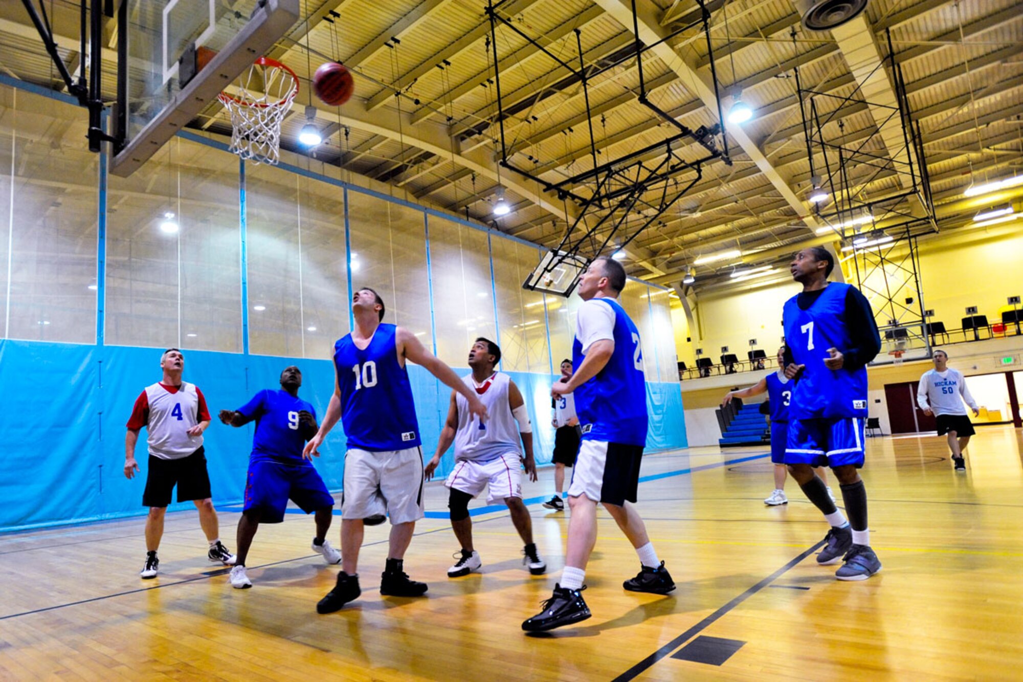 Members of the 381st Intelligence Squadron (blue jerseys) and the 673d Force Support Squadron (white jerseys) prepare for a rebound during a game, Jan. 18, at the Elmendorf Fitness Center. (U.S. Air Force photo/A!C Jack Sanders)
