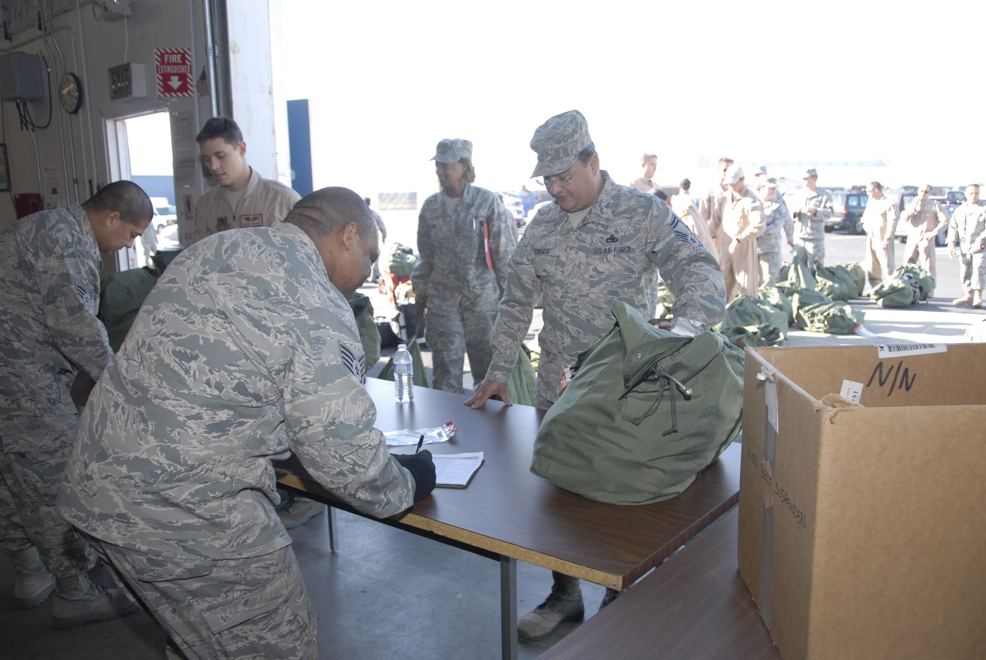 Members from the 129th Logistic Readiness Squadron's Material Management Flight, 129th Rescue Wing, Moffett Federal Airfield, Calif. assist Airmen turning in mobility bags after redeploying from overseas, Jan. 12, 2011. (Air National Guard photo by Tech. Sgt. Ray Aquino)