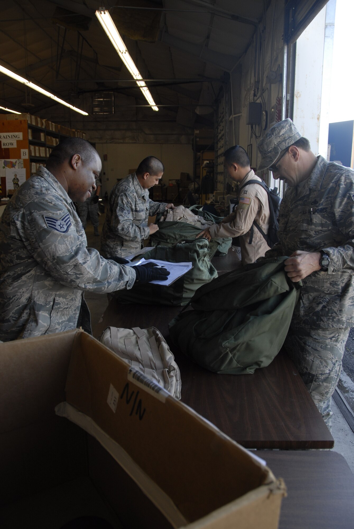 Members from the 129th Logistic Readiness Squadron's Material Management Flight, 129th Rescue Wing, Moffett Federal Airfield, Calif. assist Airmen turning in mobility bags after redeploying from overseas, Jan. 12, 2011. (Air National Guard photo by Tech. Sgt. Ray Aquino)