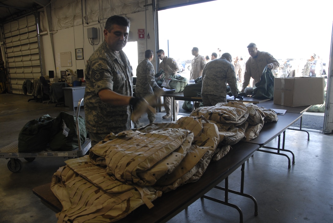 Members from the 129th Logistic Readiness Squadron's Material Management Flight, 129th Rescue Wing, Moffett Federal Airfield, Calif. assist Airmen turning in mobility bags after redeploying from overseas, Jan. 12, 2011. (Air National Guard photo by Tech. Sgt. Ray Aquino)