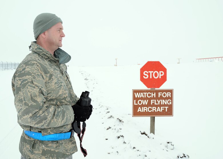 Tech. Sgt. Joseph Pierce scans the horizon for potential wildlife Jan. 5, 2010, in the flightline area at Fairchild Air Force Base, Wash. Sergeant Pierce is the 92nd Air Refueling Wing flight safety superintendent. He is a member of the bird aircraft strike hazard program, which plays an important role in everyday airfield safety by ensuring the area is free of birds and other wildlife. (U.S. Air Force photo/Tech. Sgt. JT May III)