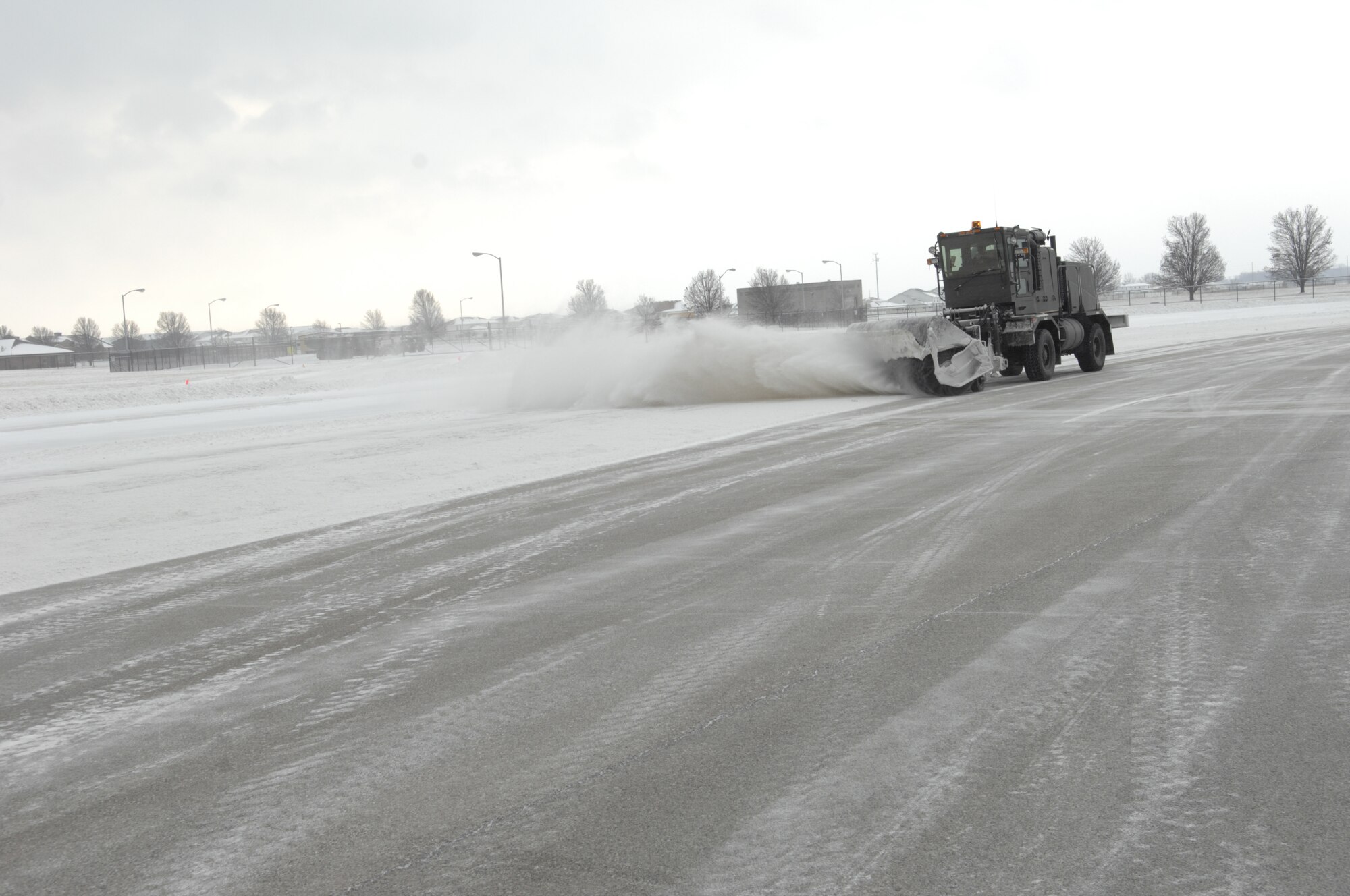 Chris Smalley, 375th Civil Engineer Squadron, sweeps the flightline Jan. 11 after Scott received its first snow fall of 2011.  To clear the airfield the squadron designates six snow blowers, six sweepers, two broom trucks, one deicer truck and one truck for solid deicer.  (U.S. Air Force photo/ Senior Airman Amber R. Kelly-Herard)