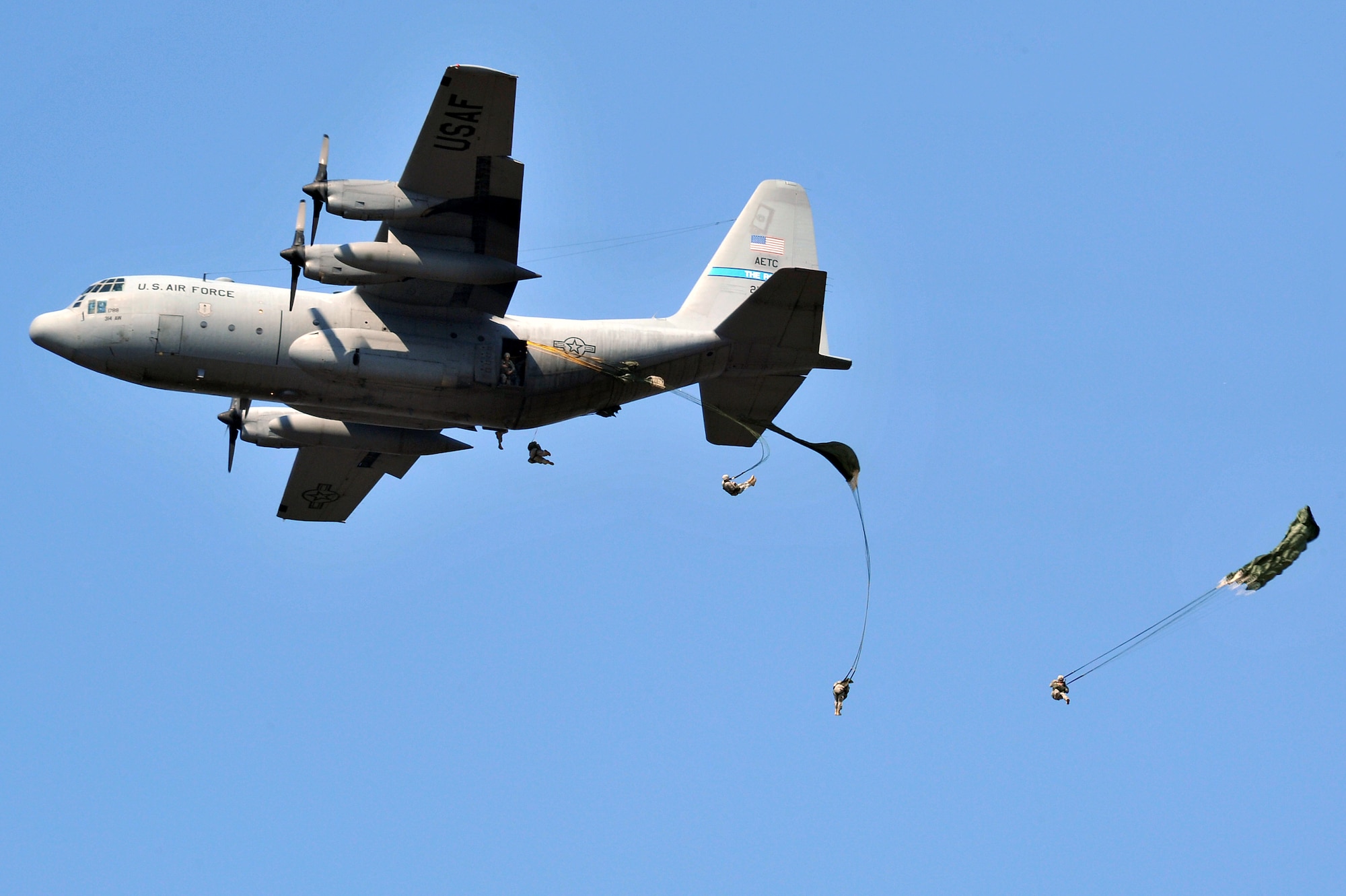 A 62nd Airlift Wing C-130 demonstrates its capabilities during an exercise with more than 400 paratroopers jumping over the base flightline Oct. 9, 2010. Approximately 225,000 guests attended the Thunder Over the Rock air show which had more than five hours of flying demonstrations and more than 40 static displays. (U.S. Air Force photo by Staff Sgt. Chris Willis)