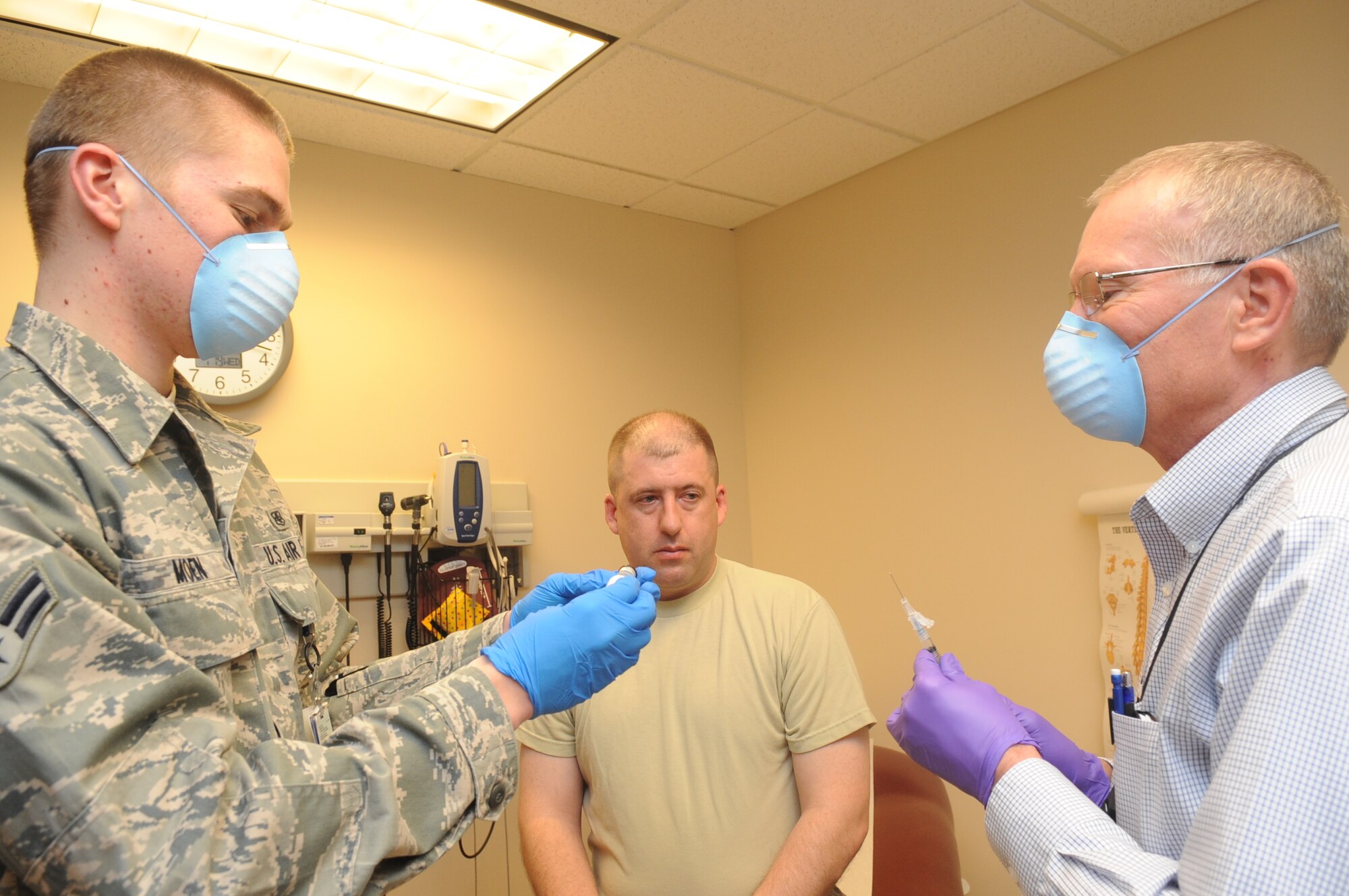 Buckley Air Force Base, Colo.-  Dr. Thomas Hadduck and Airman 1st Class Josh Moen, 460th Med Group,  prepares a shot , Jan 19, 2011. Dr. Hadduck and Airman Josh Moen were recognized during the 460th Med Group inspection for a medical procedure performed during the inspection.   ( U.S. Air Force Photo by Airman First Class Marcy Glass )