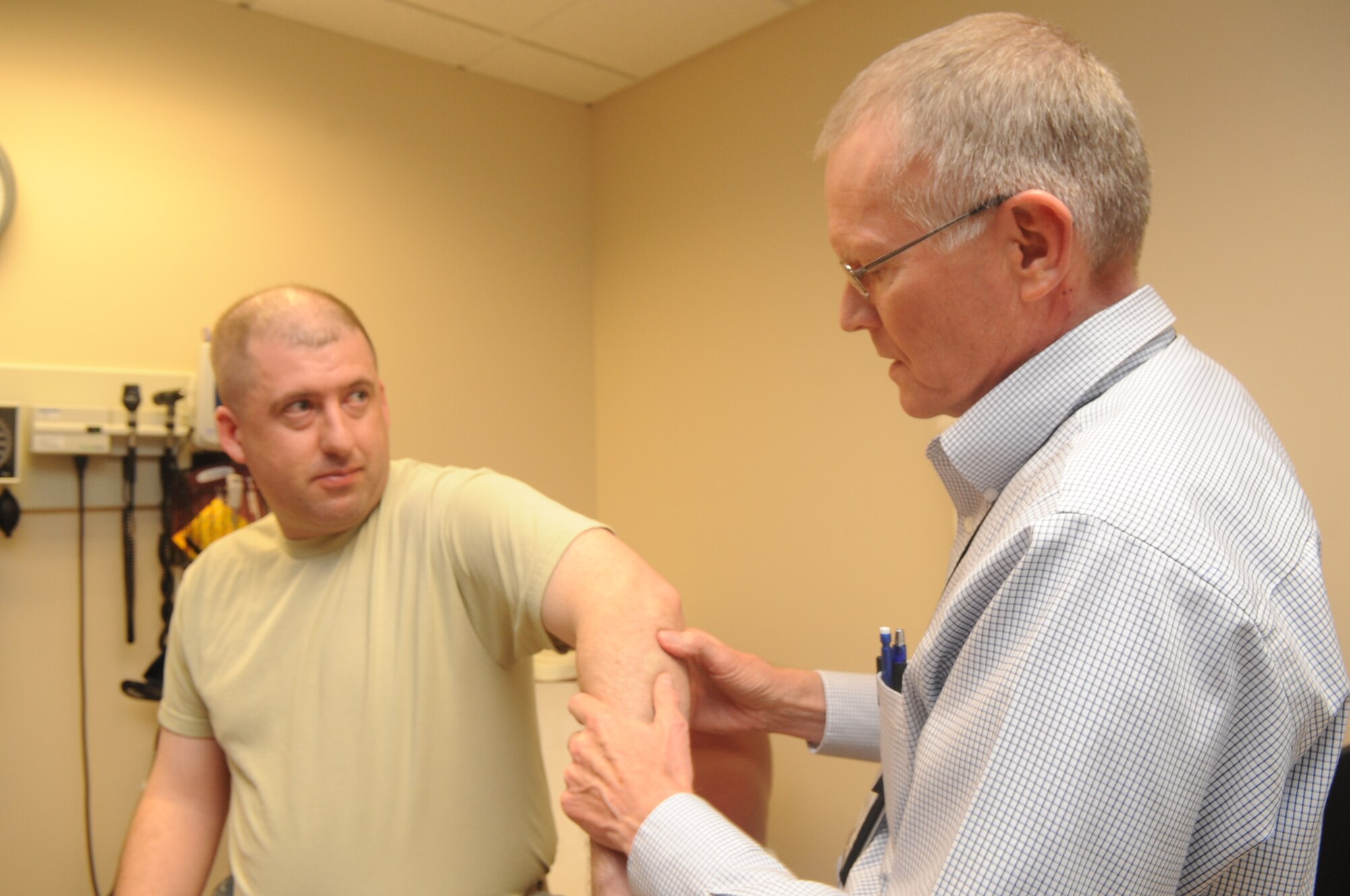 Buckley Air Force Base, Colo.-  Dr. Thomas Hadduck, 460th Med Group,  examines a patient's arm during a follow up, Jan 19, 2011. Dr. Hadduck was recognized during the 460th Med Group inspection.   ( U.S. Air Force Photo by Airman First Class Marcy Glass ) 