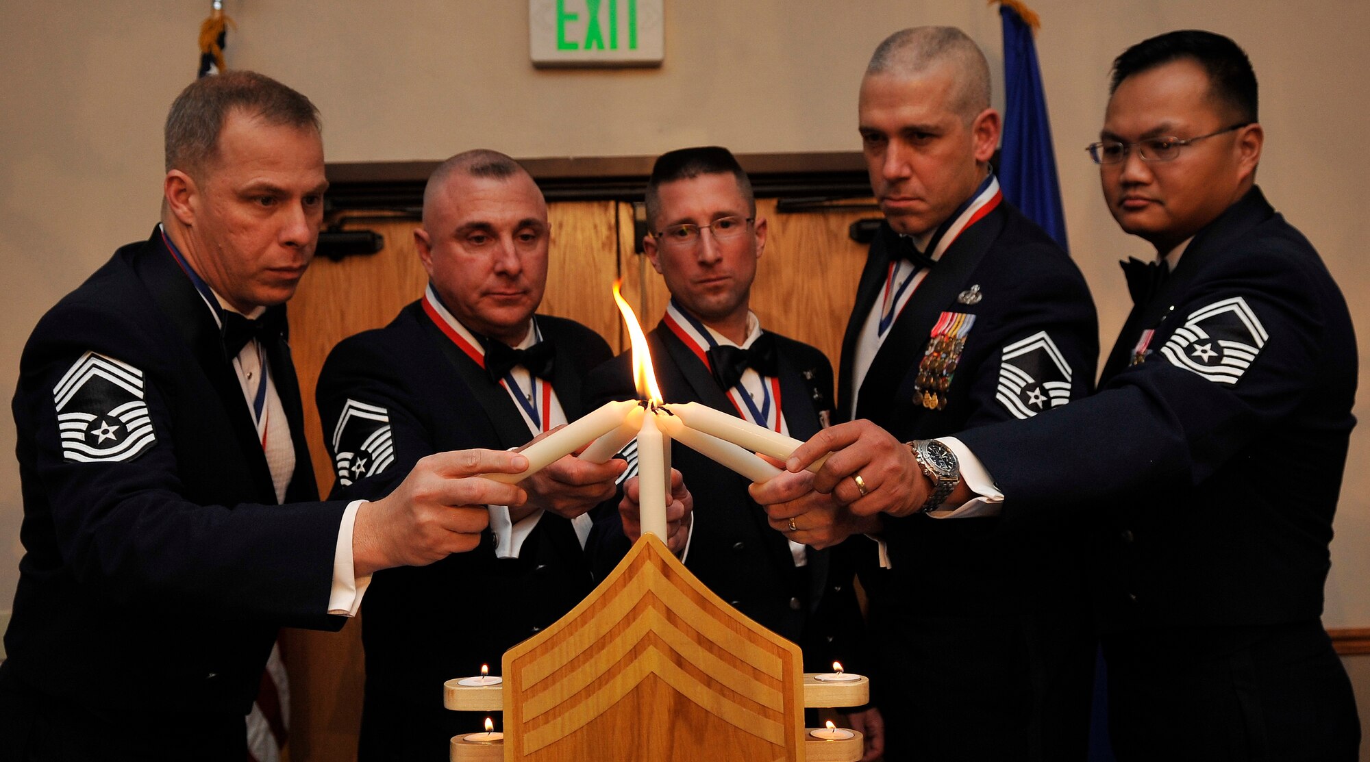 BUCKLEY AIR FORCE BASE, Colo. -- (Left to Right) Chief Master Sgt. Michael J. Wilson, Air Force Reserve Personal Center-Denver, Leon G. Palmer, 460th Security Forces Squadron, William E. Couret, Aerospace Data Facility, Robert M. Winters, Aerospace Data Facility, Edward G. Pineda, 566 Intelligence Squadron lights a candle together January 14 2010. Buckley Air Force base held their first annual Chief Recognition Ceremony.(U.S. Air Force photo by Airman 1st Class Paul Labbe.)