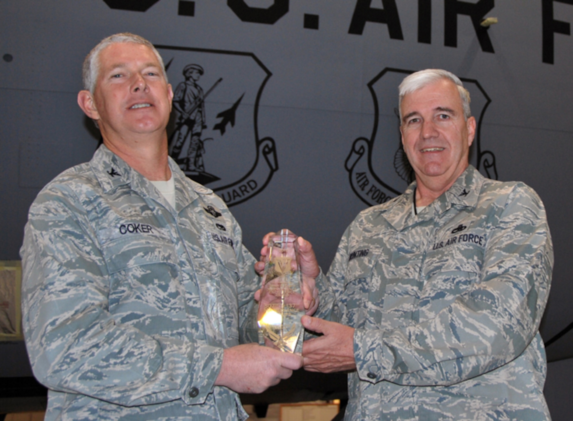 Col. Doug Coker (left), commander of the 137th Maintenance Group, and Col. Clay Bunting, commander of the 507th Maintenance Group, pose in front of a KC-135C Stratotanker aircraft while holding the Fourth Air Force’s 2010 Chief Master Sgt. James K. Clouse Trophy on January 9, 2011.  The 507th and 137th Maintenance Groups are the first associate Reserve and Guard units to win the award together.