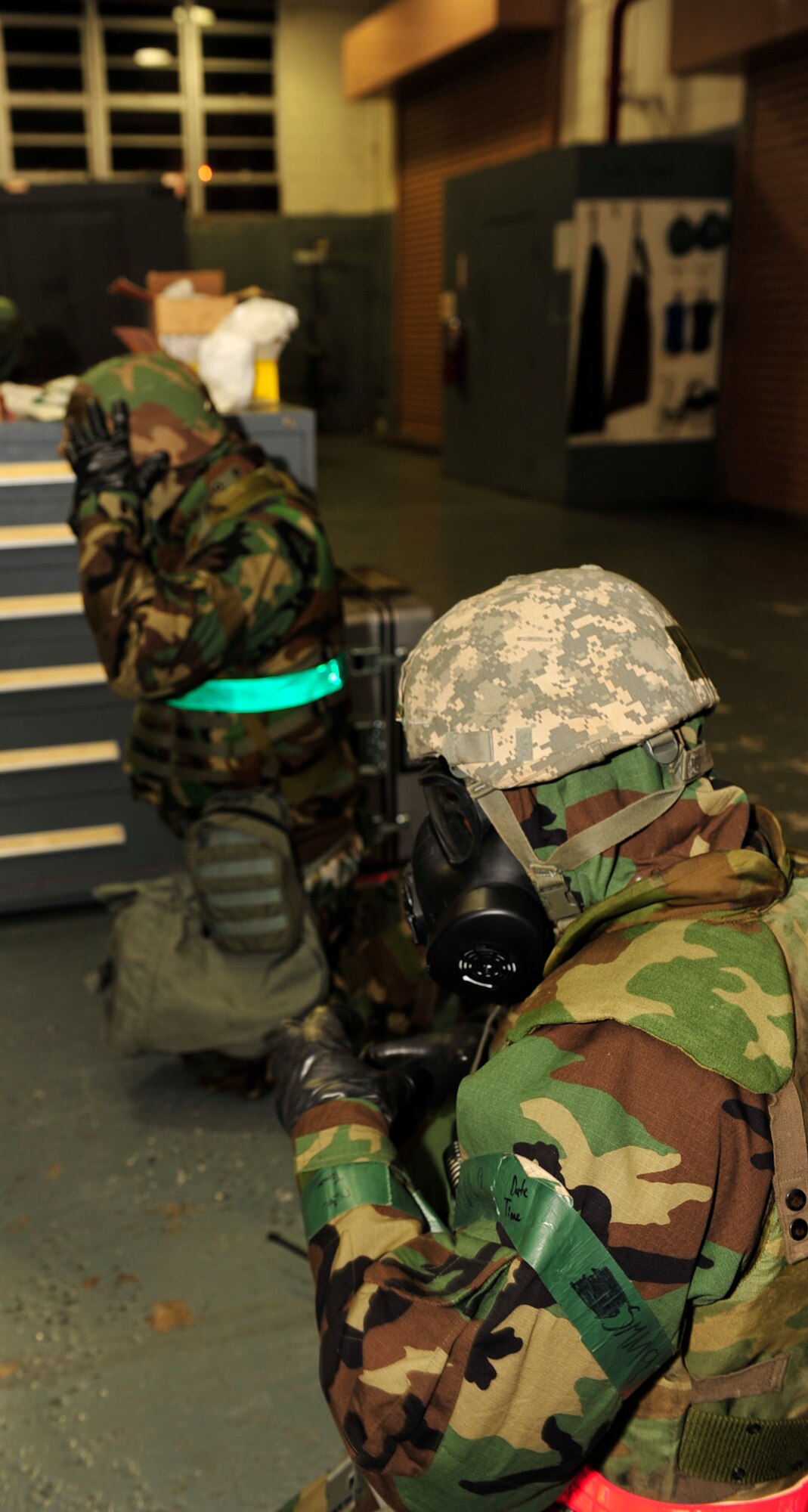 (From left to right) Staff Sgt. Joseph Gallagher and Senior Airman Diamonde Garvin, both with the 18th Equipment Maintenance Squadron, don their Mission Oriented Protective Posture gear during Beverly High 11-02, a local operational readiness exercise, at Kadena Air Base, Jan. 20. Each participant was inspected by an Exercise Evaluation Team member for accuracy in donning their gear. (U.S. Air Force photo/Staff Sgt. Lakisha A. Croley)