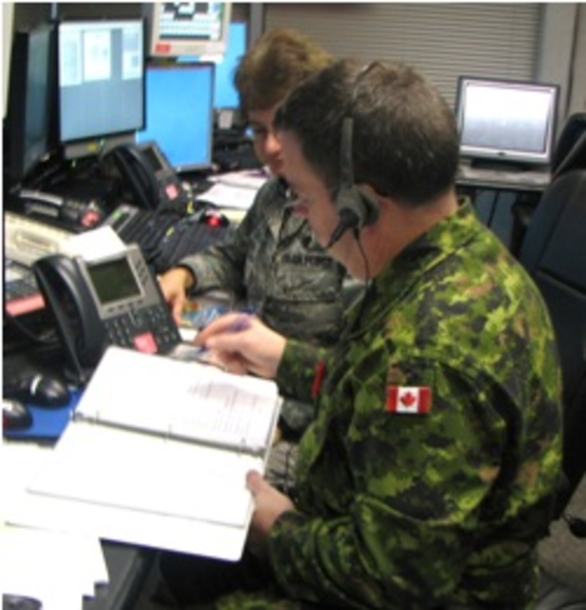 Canadian Forces Commander LCol Joseph MacMillan and EADS Director (Support) Lt. Col. Elise Hereth review a check list as part of the Vigilant Shield exercise. 