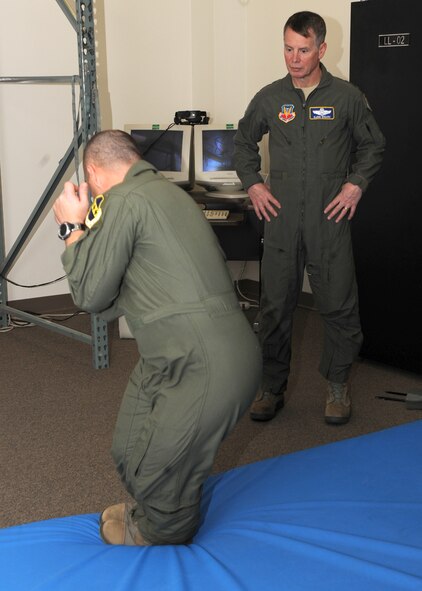 DYESS AIR FORCE BASE, Texas – Staff Sgt. Dwight Daigle, 7th Operations Support Squadron, teaches proper landing techniques in case of an emergency ejection to Lt. Gen. Glenn Spears, 12th Air Force commander, for aircrew life support training Jan. 19 here. The operations support squadron directs wing flight operations, conventional mission planning, combat tactics, airfield management, aircrew training, exercise scheduling, aircraft scheduling, weapons and tactics standardization, intelligence integration, war plans, deployment planning, weather support, small computer support, simulator training, air traffic control and wing life support functions. (U.S. Air Force Photo/Airman 1st Class Chelsea L. Cummings)