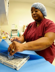 Sterilization Supervisor Gwendolyn Fields wraps a case containing dental instruments prior to sending the pack through its final sterilization phase. This four-phase process includes a thermal disinfector which initially cleans the instruments, wrapping and prepping of each pack, a heated sterilization machine and cooling and storage for later use. This process ensures the sterilization of the equipment prior to use on patients at Naval Health Clinic Charleston Dental. (U.S. Navy photo/Mass Communication Specialist 1st Class Jennifer R. Hudson)