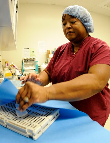 Sterilization Supervisor Gwendolyn Fields wraps a case containing dental instruments prior to sending the pack through its final sterilization phase. This four-phase process includes a thermal disinfector which initially cleans the instruments, wrapping and prepping of each pack, a heated sterilization machine and cooling and storage for later use. This process ensures the sterilization of the equipment prior to use on patients at Naval Health Clinic Charleston Dental. (U.S. Navy photo/Mass Communication Specialist 1st Class Jennifer R. Hudson)