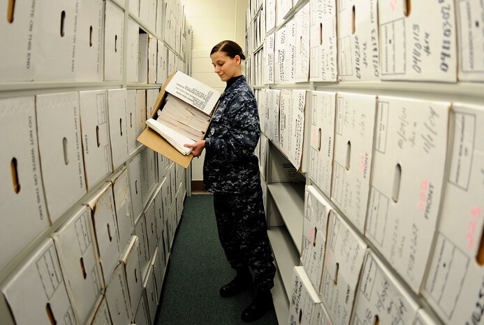 Fireman Erica Williams looks through a box filled of retained record files, verifying if the papers need to be shredded or stored for future use at Personnel Support Detachment onboard Joint Base Charleston-Weapons Station, Jan. 12. More than 500 boxes, each filled with hundreds of pieces of paper are scheduled to be processed at PSD, ensuring needed paperwork is kept while expired records are shredded. (U.S. Navy photo/Mass Communication Specialist 1st Class Jennifer R. Hudson)