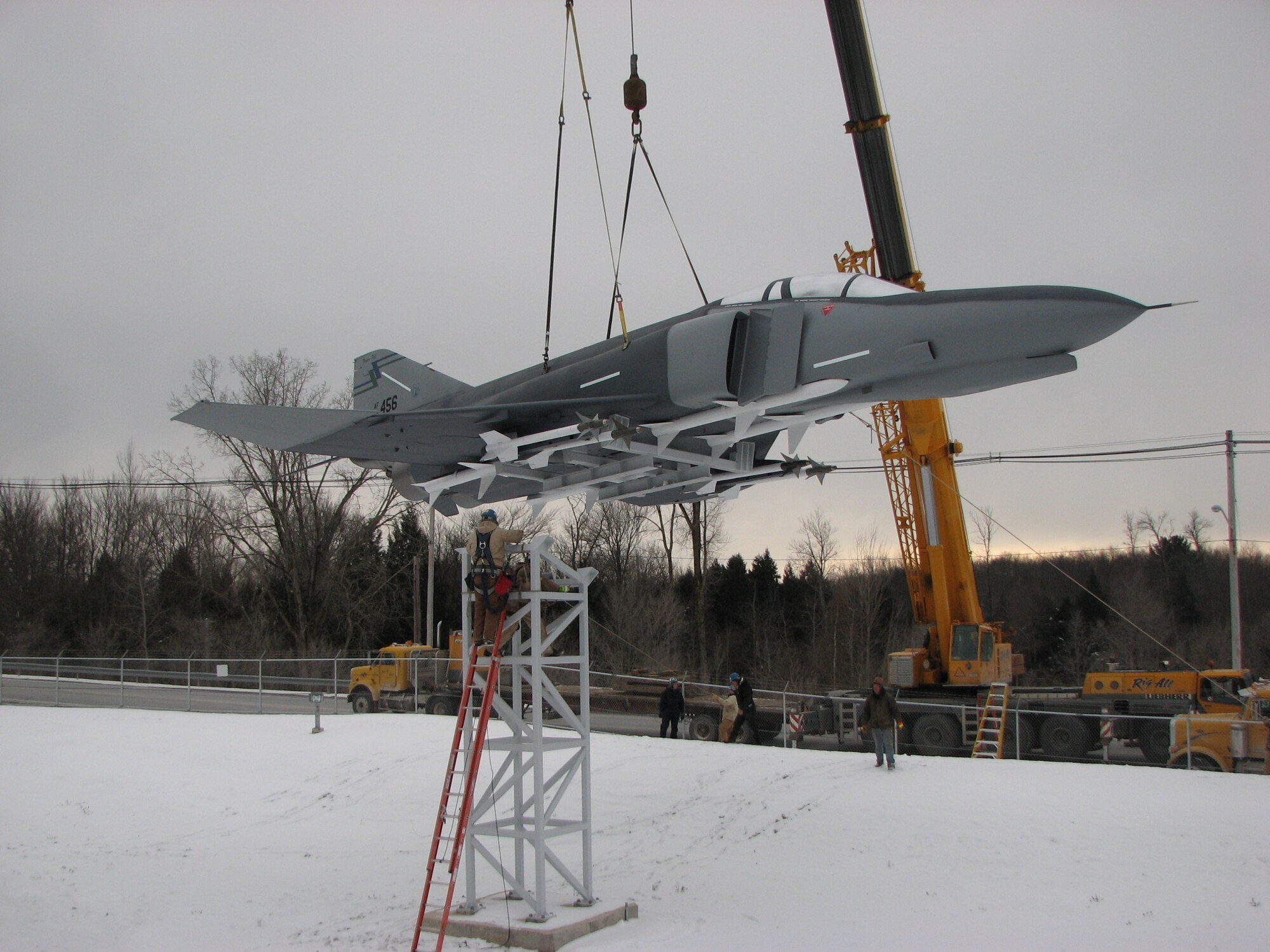 Workers lower a restored F-4 Phantom II jet onto a pedestal on Dec. 10 at the Eastern Air Defense Sector. Provided to EADS by the AFRL Rome Research Site, the plane was restored by the Mohawk Valley Community College Aviation Training Center.