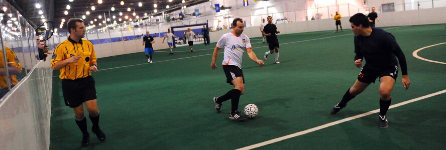 OFFUTT AIR FORCE BASE, Neb. - Tom Deppe, a contractor with the Air Force Weather Agency, work the ball down the indoor soccer field against the 55th Security Forces Squadron's soccer team during a league game held at the Offutt Field House, Jan. 12. U.S. Air Force Photo by Josh Plueger (Released)