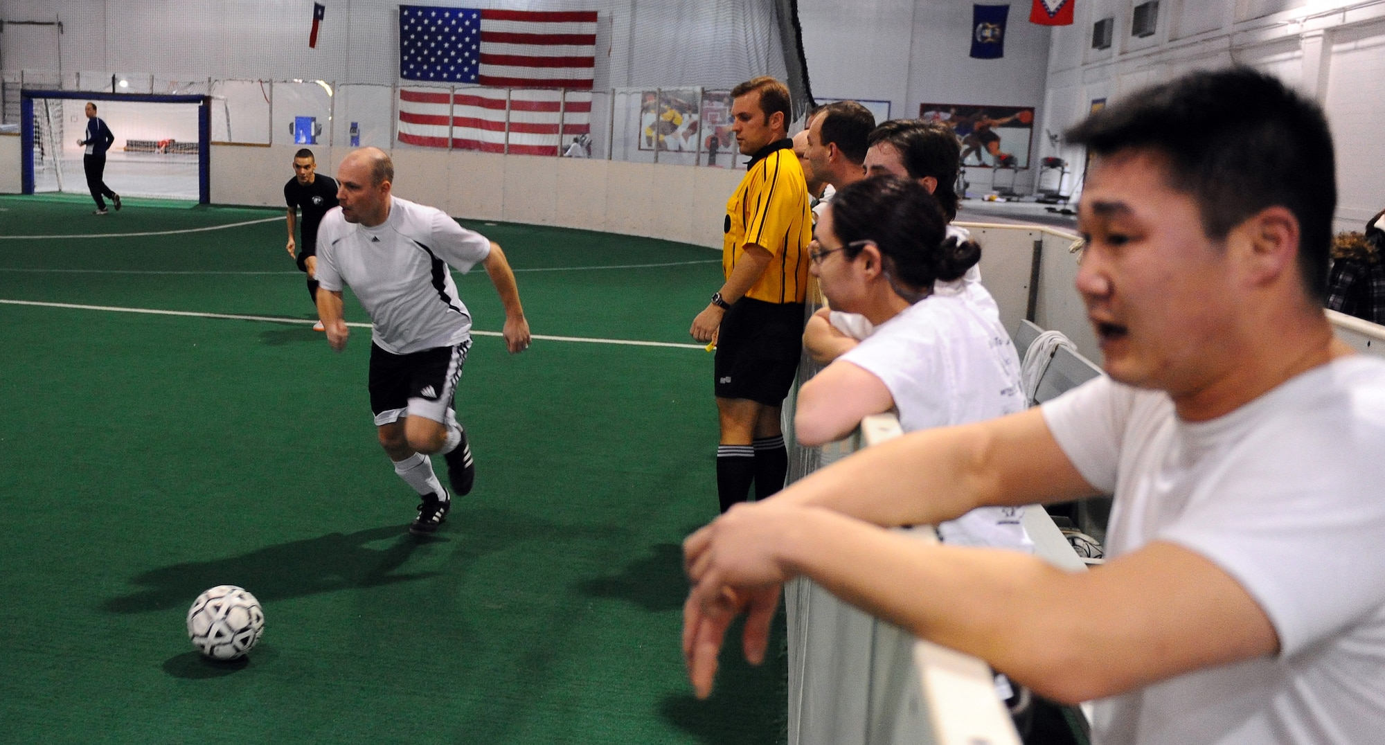 OFFUTT AIR FORCE BASE, Neb. - Sean Medcalf, a contractor with the Air Force Weather Agency, drives toward the 55th Security Forces Squadron's side of the field during a league game at the Offutt Field House, Jan. 12. The indoor soccer league is in full swing for the 2011 season. U.S. Air Force Photo by Josh Plueger (Released)