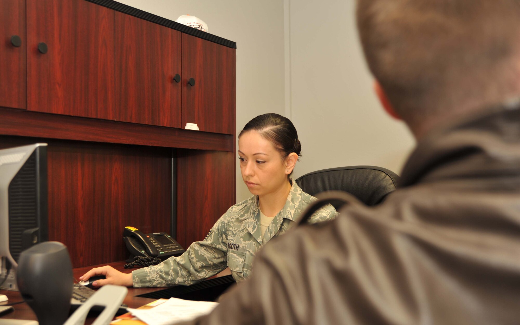 Tech. Sgt. Rosemarie Booth, 22nd Force Support Squadron career development NCOIC, assists a customer with their outprocessing paperwork Jan. 18, 2011, McConnell Air Force Base, Kan.  The Hollister, Calif., native oversees McConnell’s promotions, duty assignments, retirements, separations, reenlistments and extensions.  U.S. Air Force photo/Senior Airman Abigail Klein)