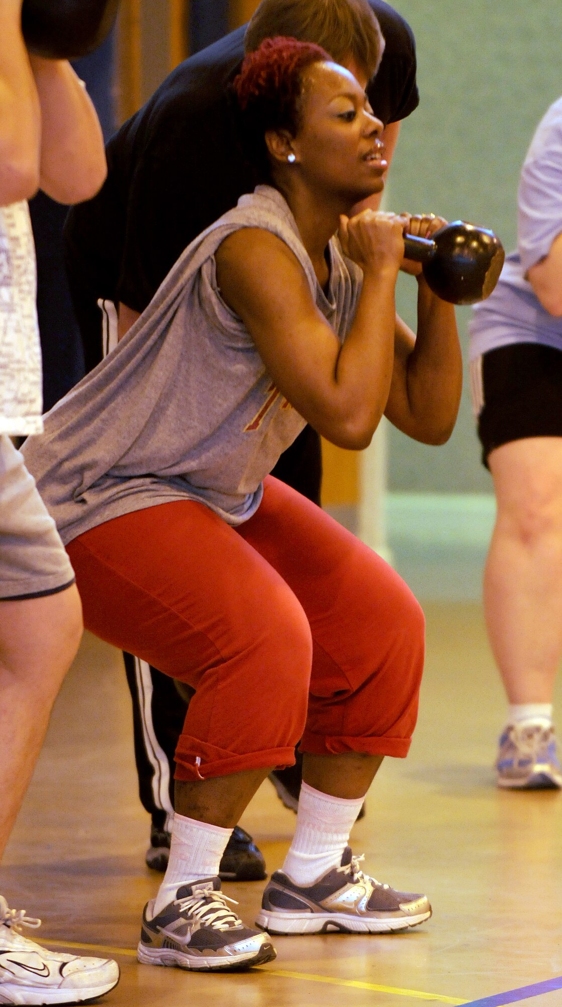 RAF MILDENHALL, England -- Toya Jenkins does weighted squats during a High Intensity Interval Training class here Jan. 13, 2011.  Mrs. Jenkins is participating in the Biggest Loser competition and her goals are to lose 30 pounds and increase her overall health. (U.S. Air Force photo/Senior Airman Tabitha M. Lee) 