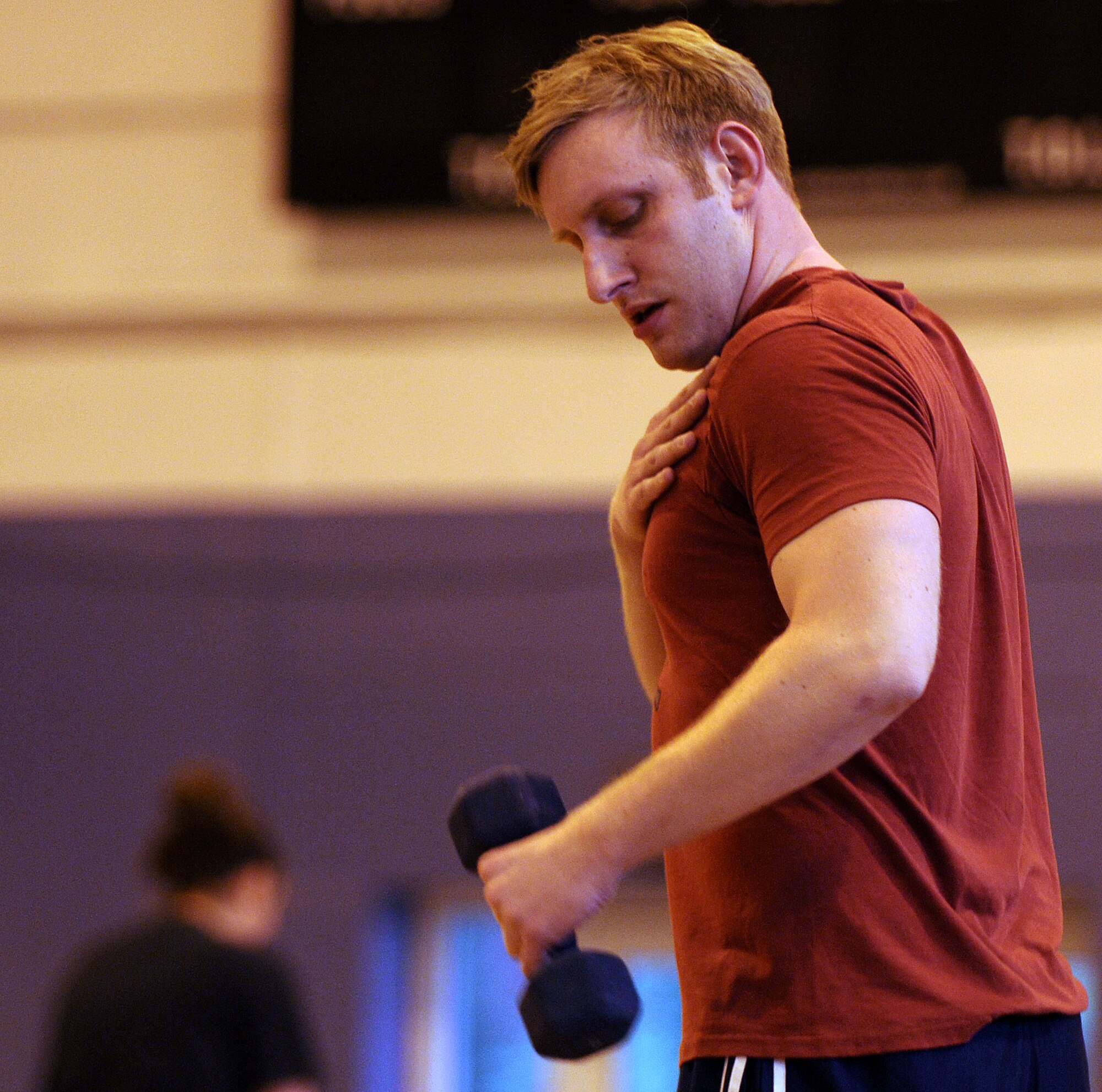 RAF MILDENHALL, England -- Tech. Sgt. Ronald Cooney, 100th Air Refueling Wing Air Force Smart Operations for the 21st Century wing facilitator, does arm curls during a High Intensity Interval Training class here Jan. 13, 2011.  Sergeant Cooney is participating in the Biggest Loser competition and his goals are to lose 14 pounds and be able to run a half-marathon. (U.S. Air Force photo/Senior Airman Tabitha M. Lee) 