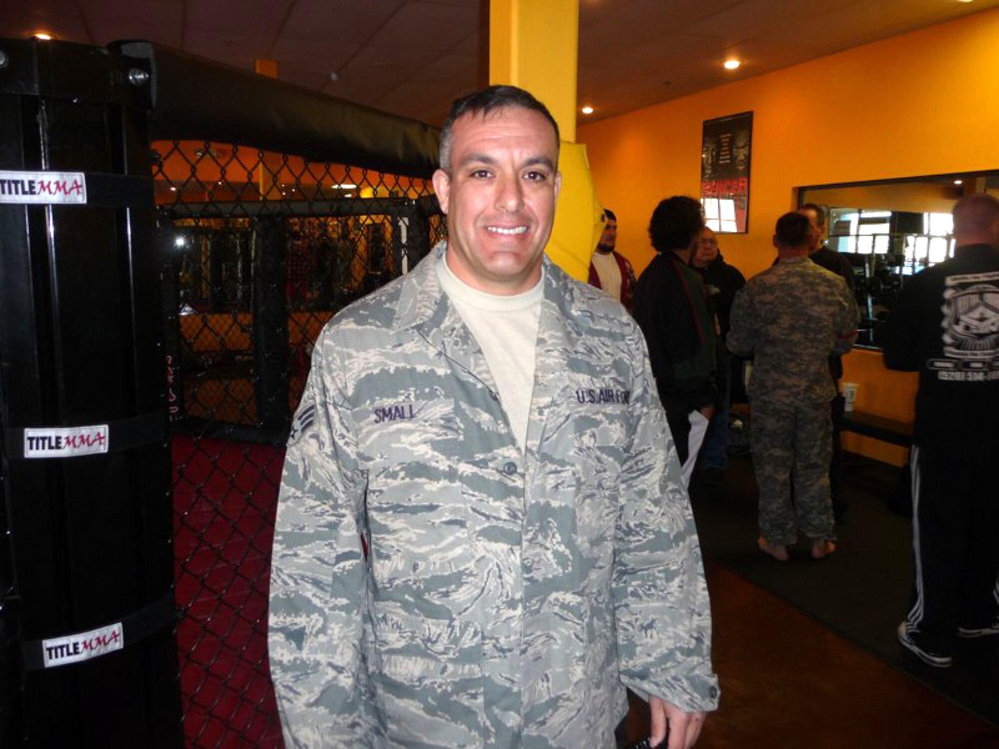 Senior Airman Ed Small waits for his next match at the Arizona National Guard Combatives Team tryouts Jan. 15. Competitors wear the Army Combat Uniform or Airman Battle Uniform without boots. For grappling and Pancrase matches, they must also leave their shirts unbuttoned to allow their opponents to effectively grab their clothes for throws and takedowns. (U.S. Air Force photo/Master Sgt. Dave Morgan)