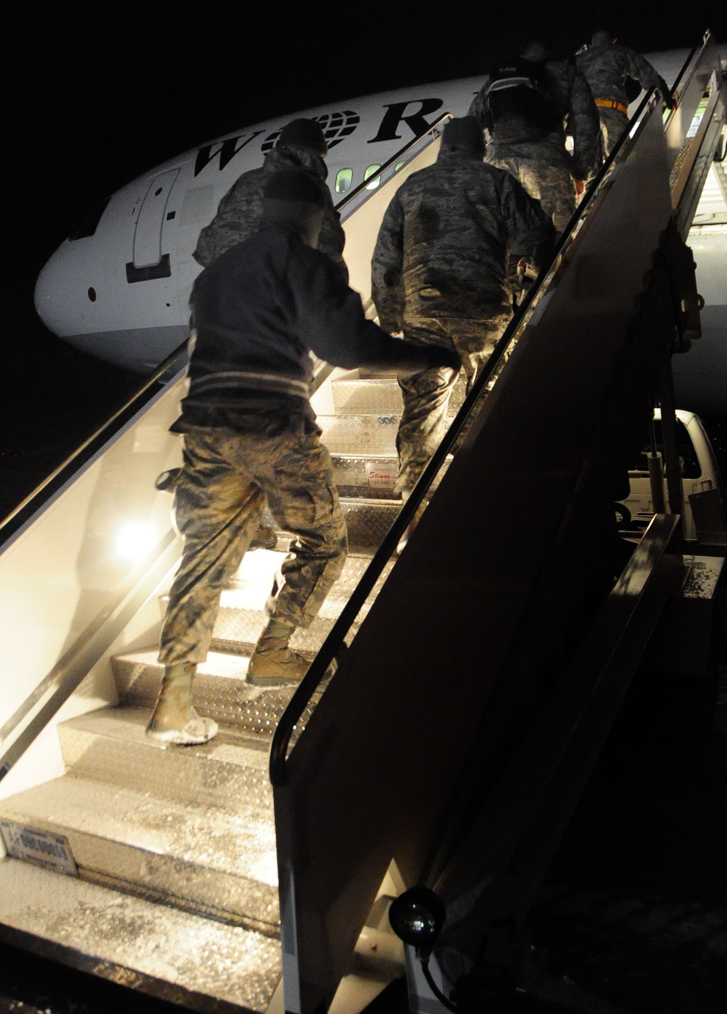 Airmen from Ellsworth Air Force Base, S.D., climb aboard their plane as they prepare to depart for Southwest Asia, Jan. 15, 2011.  Approximately 300 Airmen deployed in support of overseas contingency operations. (U.S. Air Force photo/Senior Airman Anthony Sanchelli)
