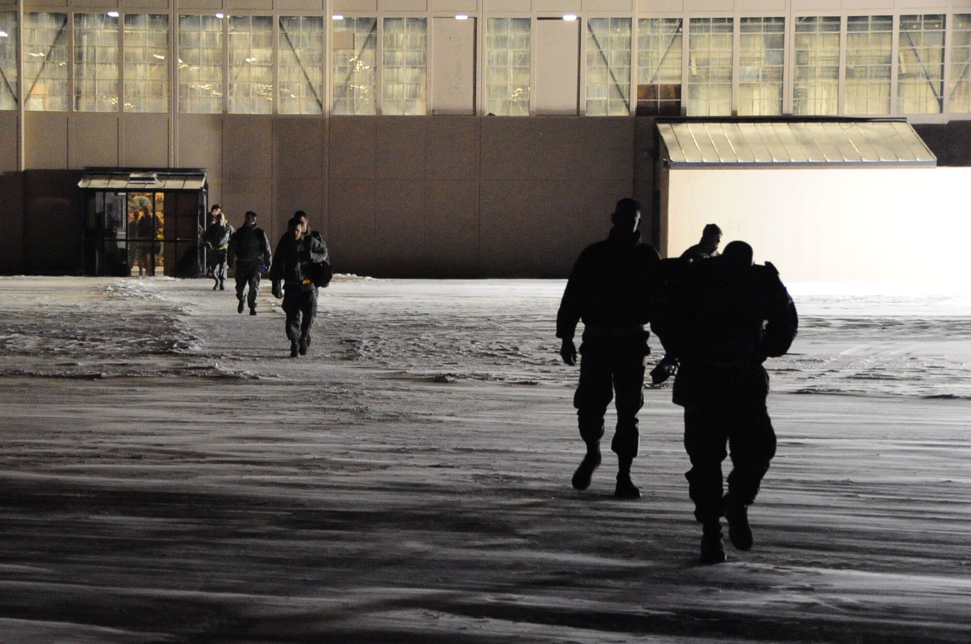 Airmen from Ellsworth Air Force Base, S.D., prepare to board their plane in bitterly cold and windy weather before departing for Southwest Asia, Jan. 15, 2011.  Approximately 300 Airmen deployed in support of overseas contingency operations. (U.S. Air Force photo/Senior Airman Anthony Sanchelli)
