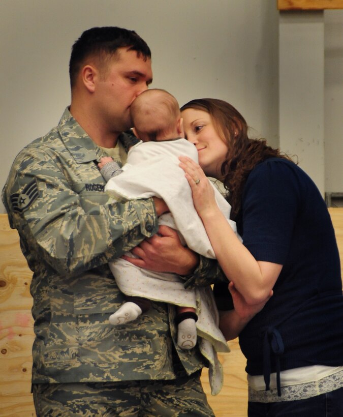 Staff Sgt. Glenn Rogers, 28th Maintenance Squadron aircraft fuel systems repair craftsman, waits with his wife and child before processing through a deployment line at Ellsworth Air Force Base, S.D. on Jan. 12, 2011.  Sergeant Rogers was part of a small cadre that deployed in advance of a larger group of Airmen that deployed in support of overseas contingency operations on Jan. 15, 2011. (U.S. Air Force Photo/Senior Airman Anthony Sanchelli)
