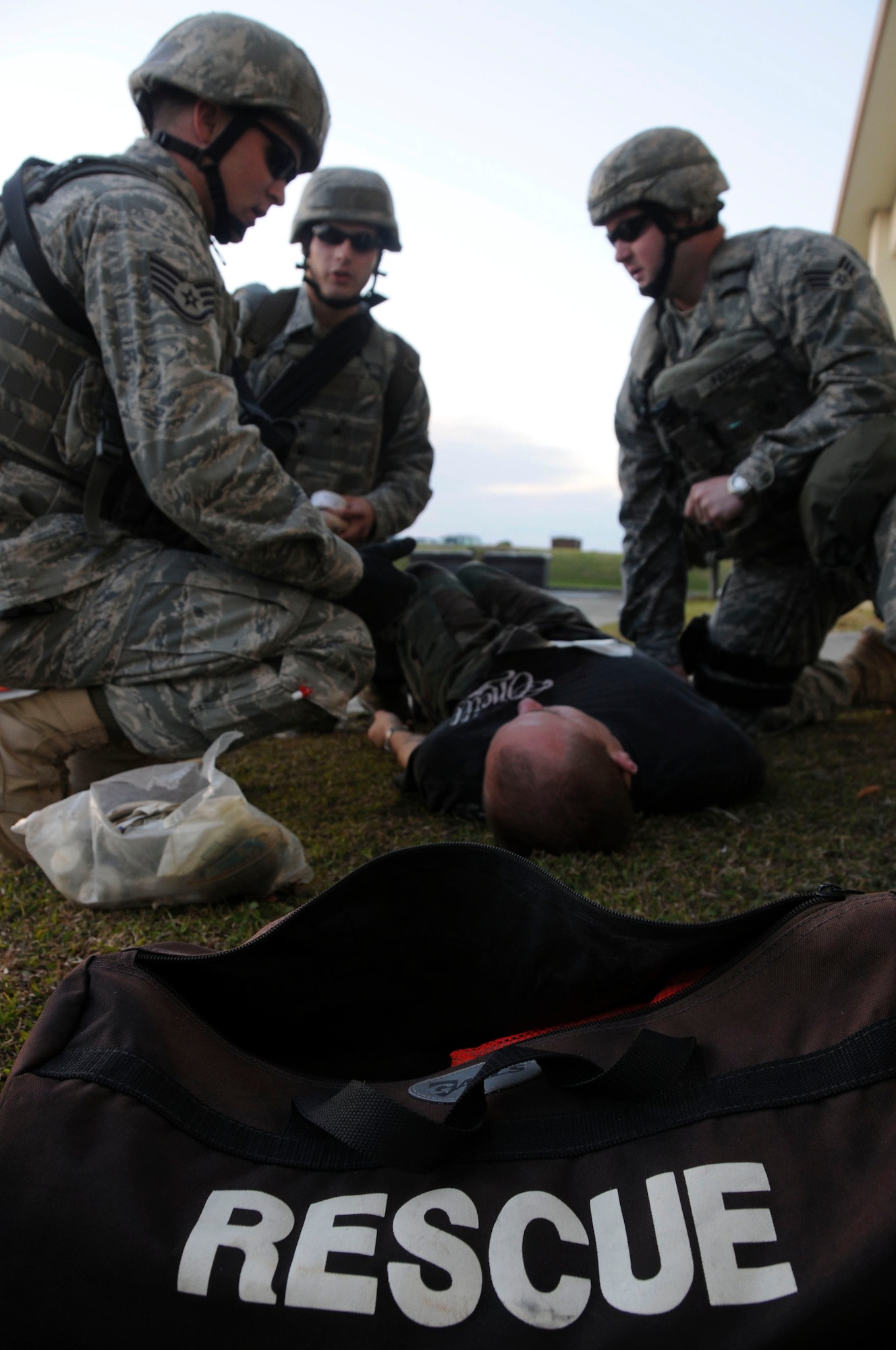 Members of the 18th Security Forces Squadron use the equipment from a first aid kit to treat simulated injury during Beverly High 11-02, a local operational readiness exercise, Jan. 19. This scenario tested the 18th SFS ability to respond to a building that has been attacked and provide immediate care to the injured personnel. (U.S. Air Force photo/Staff Sgt. Darnell T. Cannady)
