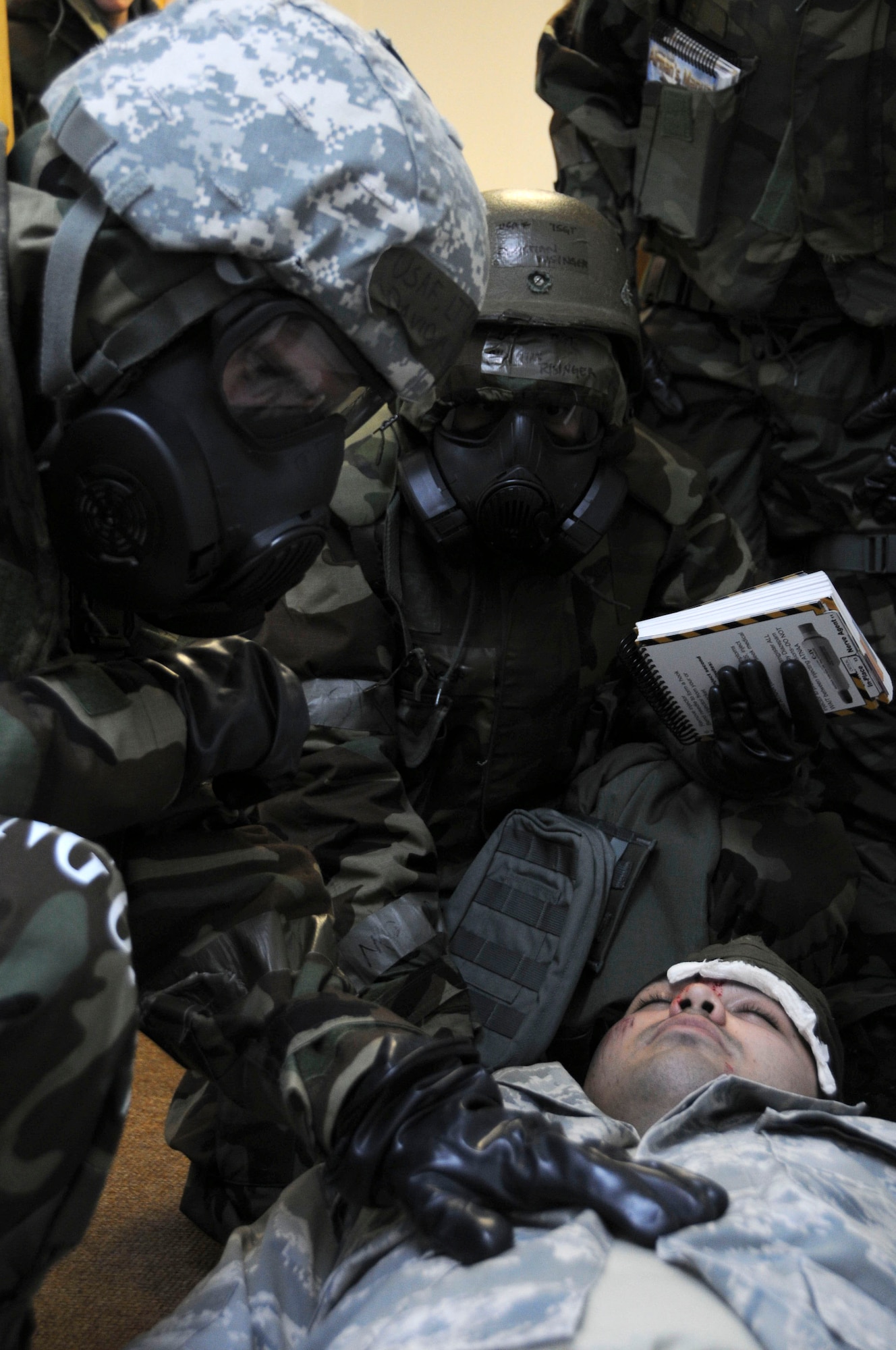 Lt. Col. David Mineau, 18th Operations Support Squadron commander, and Tech. Sgt. Christian Risinger, 18th Operations Support Squadron aviation resource manager, checks on the health of a simulated injured Airman during a building evacuation scenario at Kadena Air Base, Jan. 19. This scenario was part of the local operational readiness exercise that tested the 18th OSS’s ability evacuate a building that has been attacked and provide care to the casualties. (U.S. Air Force photo/Staff Sgt. Darnell T. Cannady) 