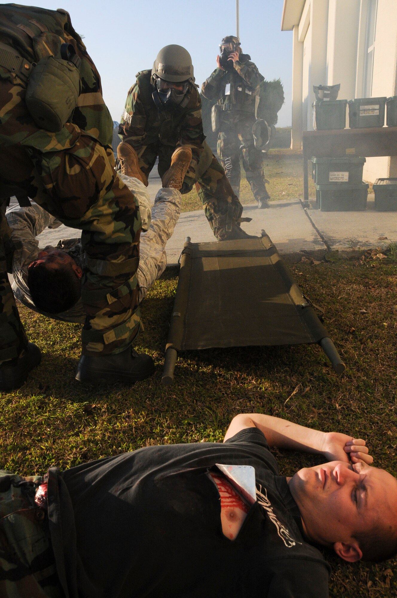 Lt. Col. David Mineau, 18th Operations Support Squadron commander, and Major Milad Youssef, 18th Operations Support Squadron assistant director of operations, lifts a simulated injured person onto a liter during a building evacuation scenario at Kadena Air Base, Jan. 19. This scenario was part of Beverly High 11-02, a local operational readiness exercise, which tested the 18th OSS’s ability to tend to injured personnel and transport them to a safe location. (U.S. Air Force photo/Staff Sgt. Darnell T. Cannady)