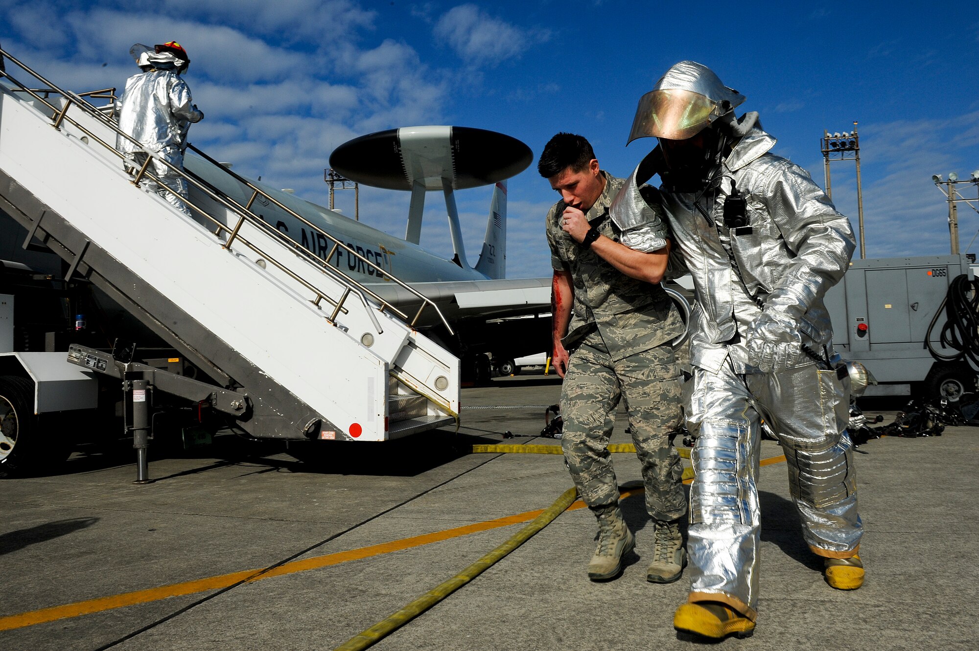A firefighter from the 18th Civil Engineer Squadron helps a simulated victim from a simulated E-3 Sentry engine fire Jan. 19. The simulated engine fire was a scenario during Beverly High 11-02, a local operational readiness exercise. (U.S. Air Force photo/Staff Sgt. Jonathan Steffen) 