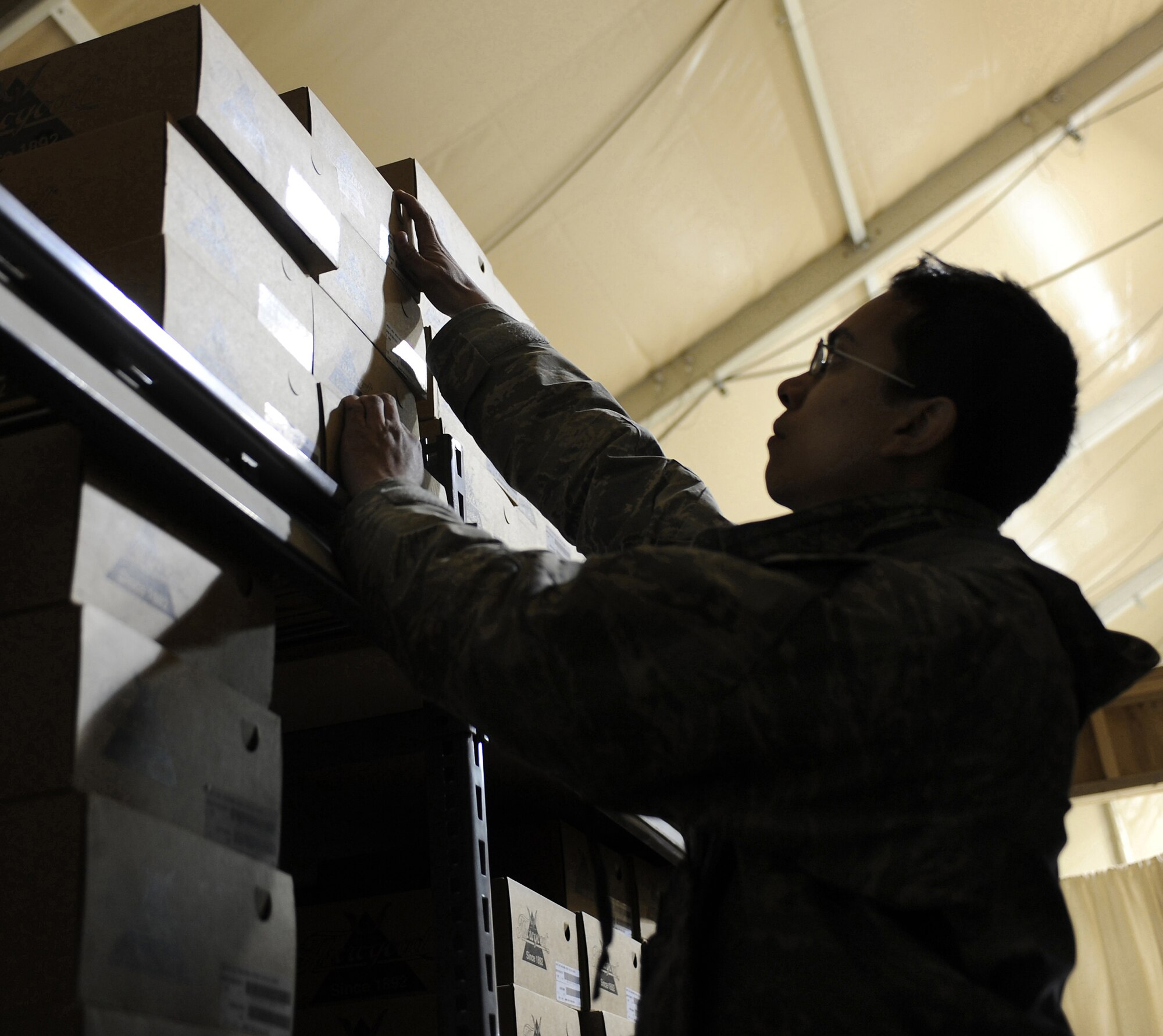 Senior Airman Troy Cabal locates a pair of boots on a storage shelf in the 451st Expeditionary Logistics Readiness Squadron customer service building Jan. 17, 2011, at Kandahar Airfield, Afghanistan. The 451st ELRS Airmen manage more than $10,000 in clothing supply assets available to Airman. Airman Cabal is a customer service representative assigned to the 451st ELRS. (U.S. Air Force photo/Senior Airman Willard E. Grande II)