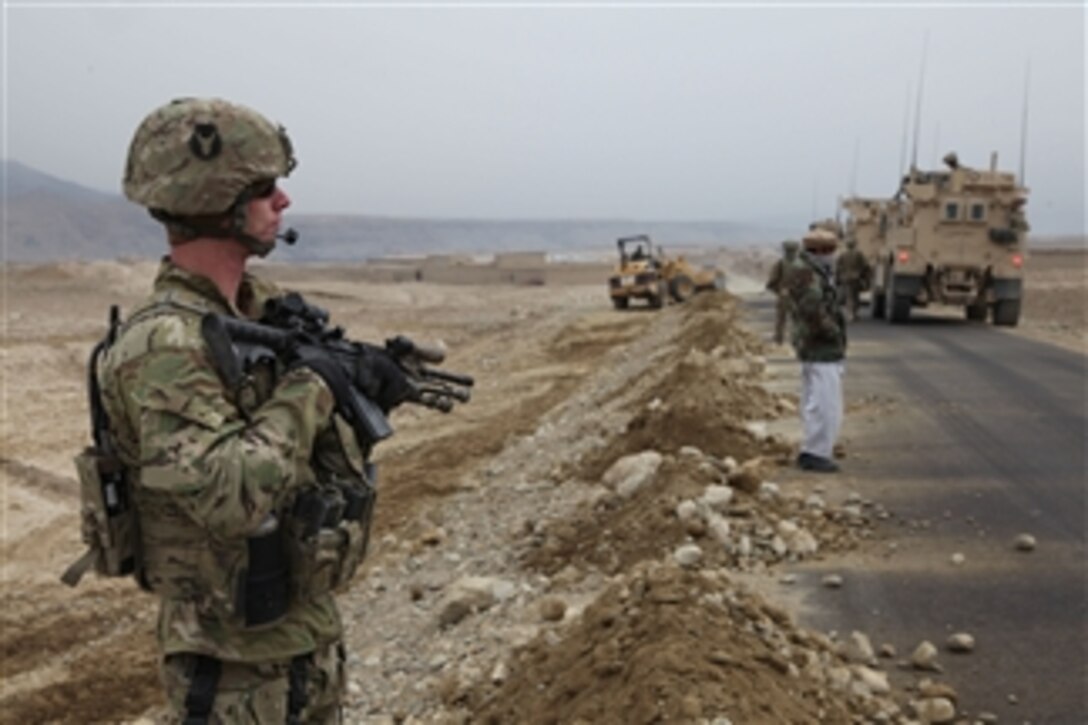 U.S. Army Sgt. James Vanveldhulzen (left), an infantryman with Alpha Troop, 1st Squadron, 113th Cavalry Regiment, 2nd Brigade Combat Team, 34th Infantry Division, provides security during a dismounted patrol in Parwan province, Afghanistan, on Jan. 13, 2011.  